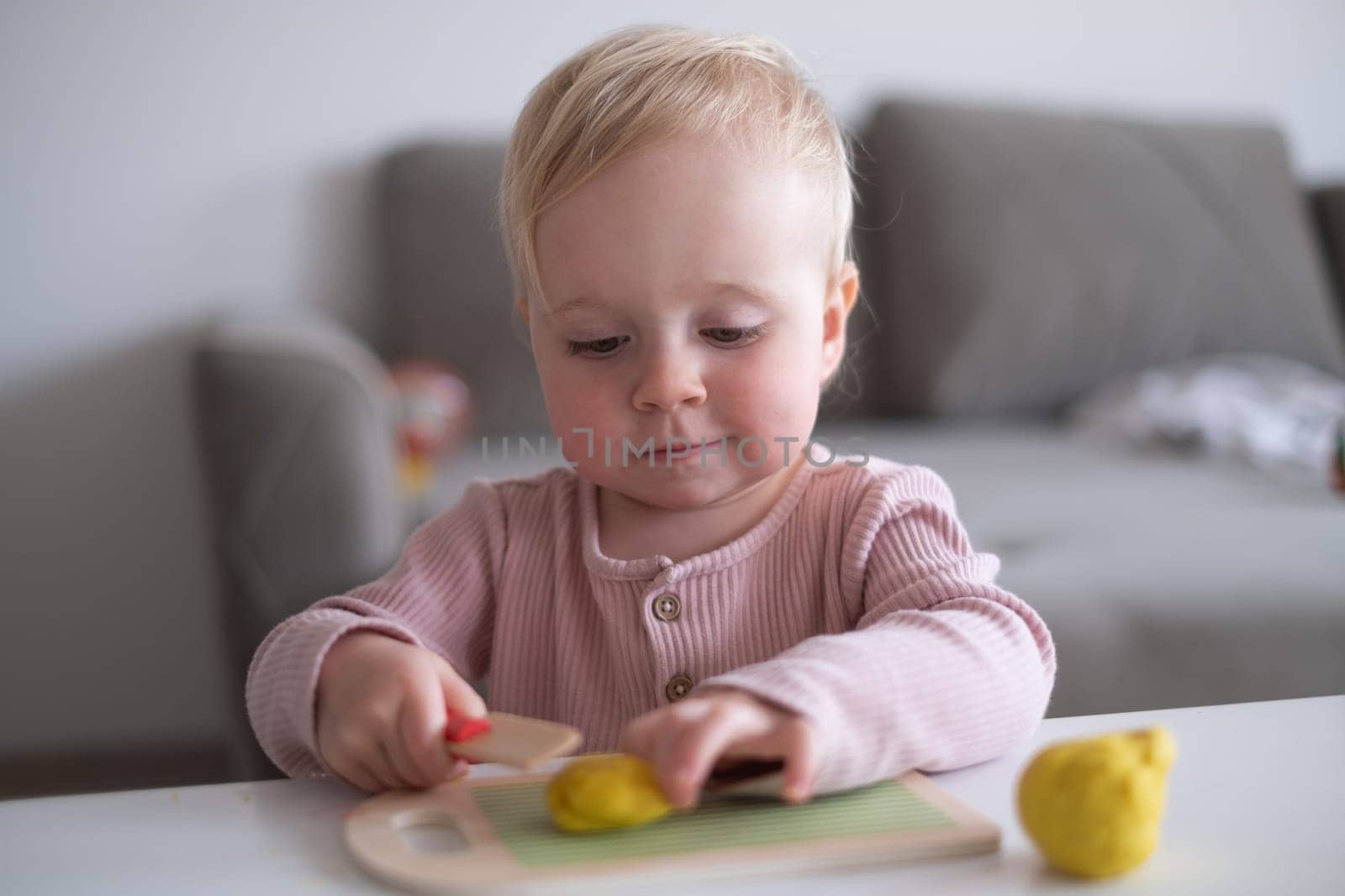 Portrait of smiling little toddler working with plasticine in art and craft class