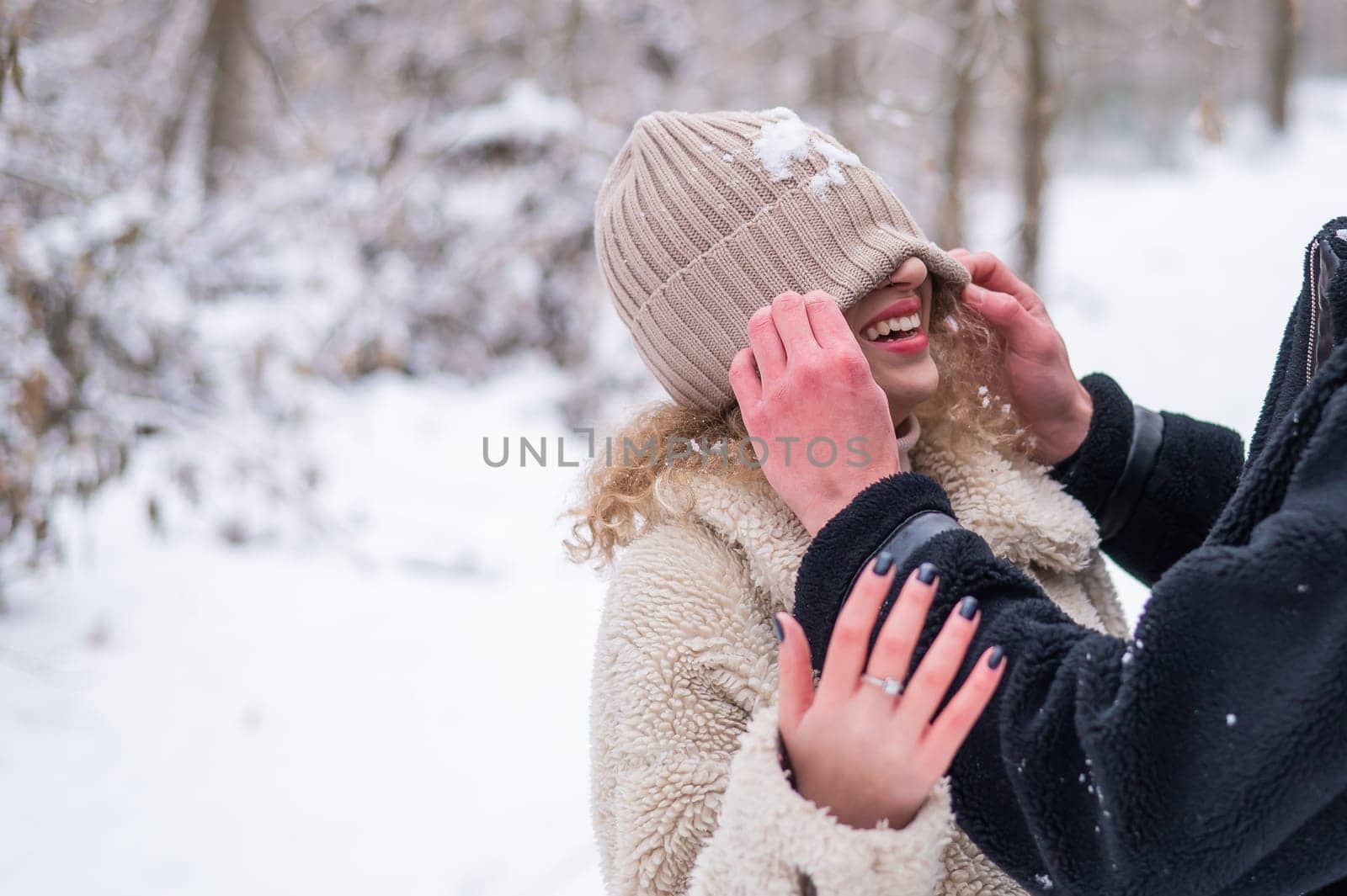 A young couple walks in the park in winter. Guy and girl fooling around on the street. by mrwed54