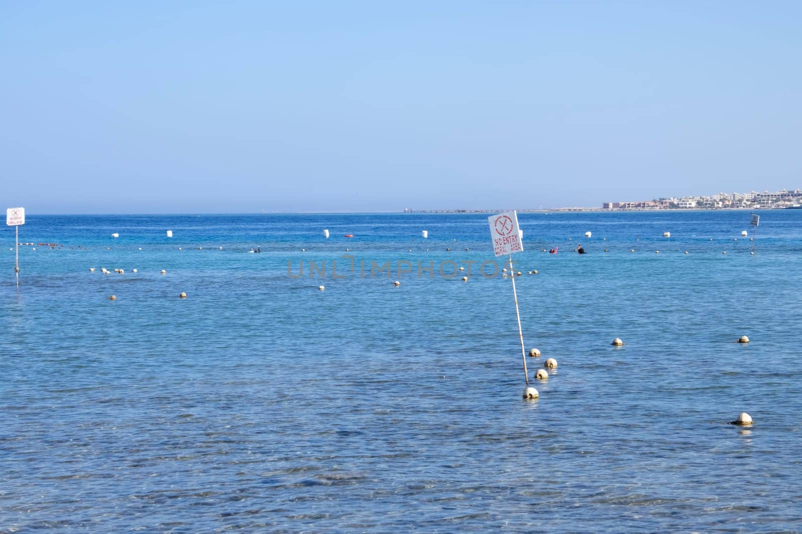 A clear blue sea with buoys and a distant shore, offering a tranquil and peaceful marine view.