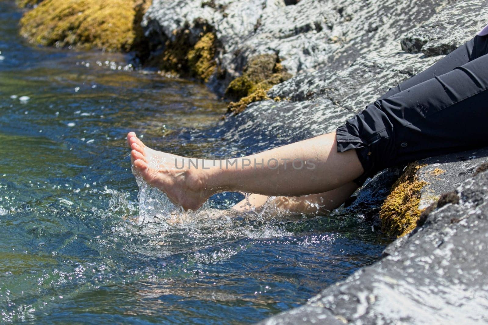 A concept lifestyle photo of the legs of a woman splashing in the water from the river in north Idaho.