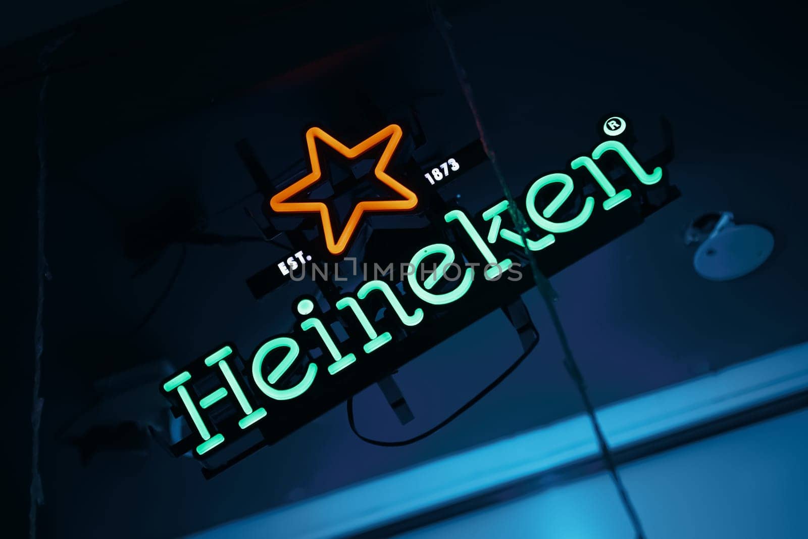 View of Heineken neon light sign at a pub. Heineken is a Dutch brewing company, founded in 1864 by Gerard Adriaan Heineken in Amsterdam. BISHKEK, KYRGYZ REPUBLIC - 25 JULY 2021