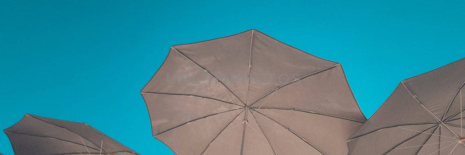 Banner of beach umbrellas against the background of a clear blue sky. vacation and beach holiday concept. soft focus.