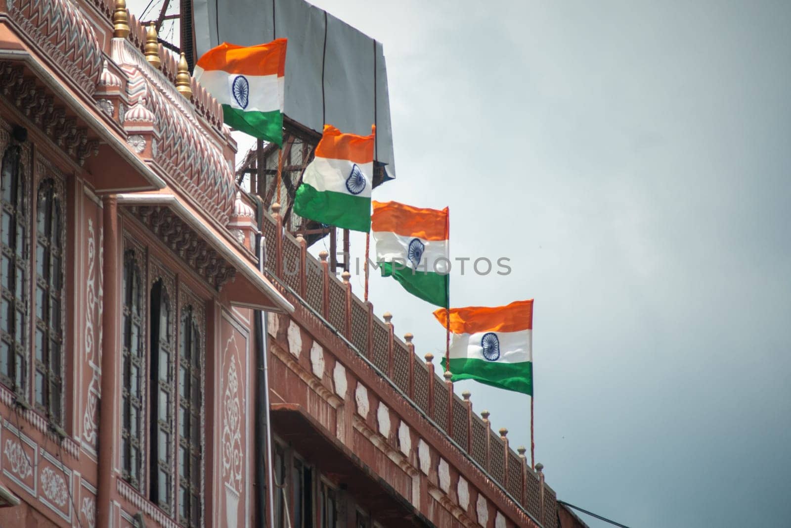 Line of Indian tricolor flag mounted on top of building showing national pride and celebration of independence and republic day. Shot with shallow depth of field