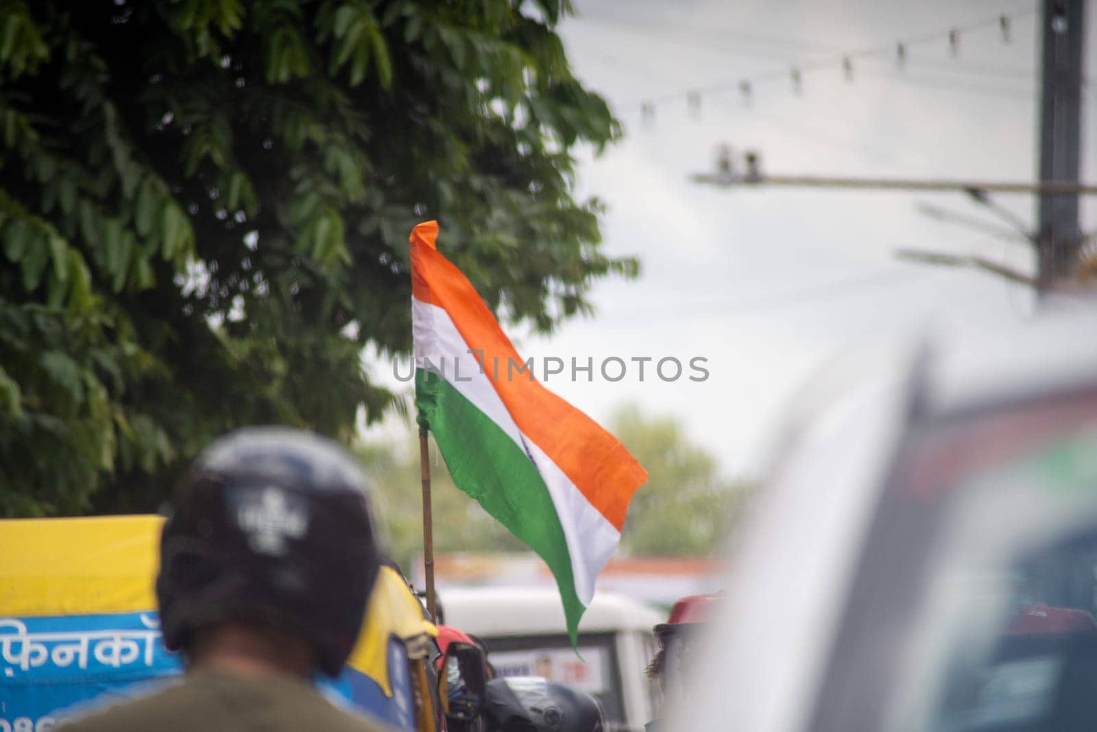 Indian tricolor flag mounted on vehicle in middle of traffic showing national pride and celebration of independence and republic day. Shot with shallow depth of field