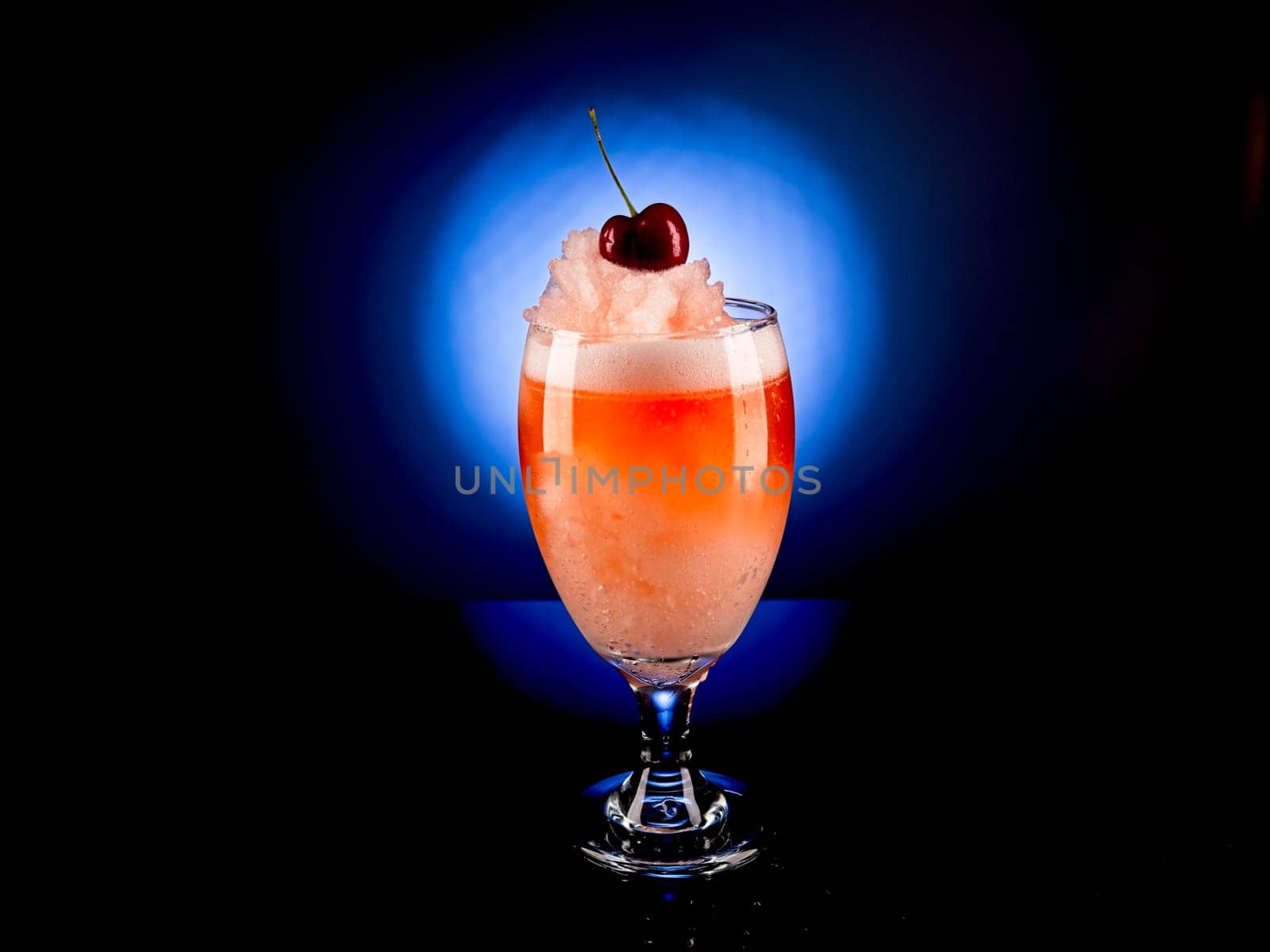 Close up studio photo of a frozen cocktail with a cherry on top.