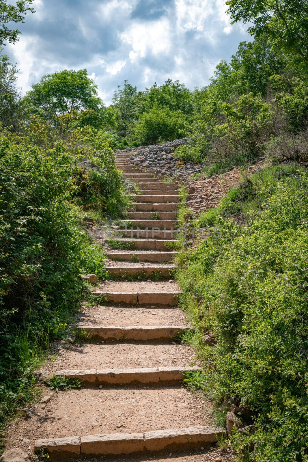 the hiking trail with steep steps up to the top of the Roche de Solutre to the giant rock to climb Burgundy, France