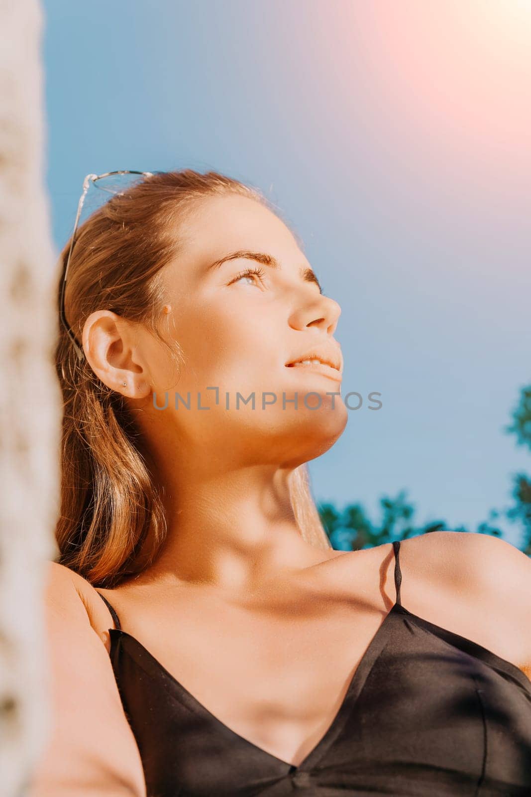 Woman travel sea. Young Happy woman in a long red dress posing on a beach near the sea on background of volcanic rocks, like in Iceland, sharing travel adventure journey