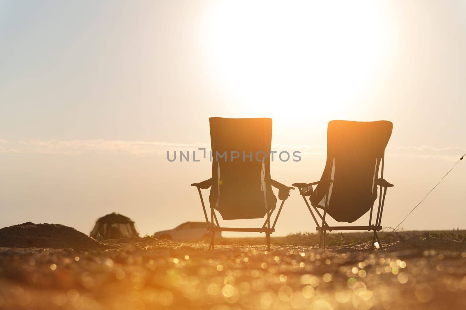 Two empty camping chairs on the ground. An ideal place to watch sunset or sunrise. Active relaxing lifestyle by yanik88