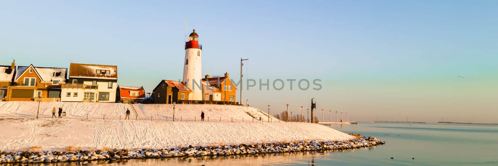 Lighthouse of Urk Netherlands during sunset in the Netherlands during winter with snow white landscape
