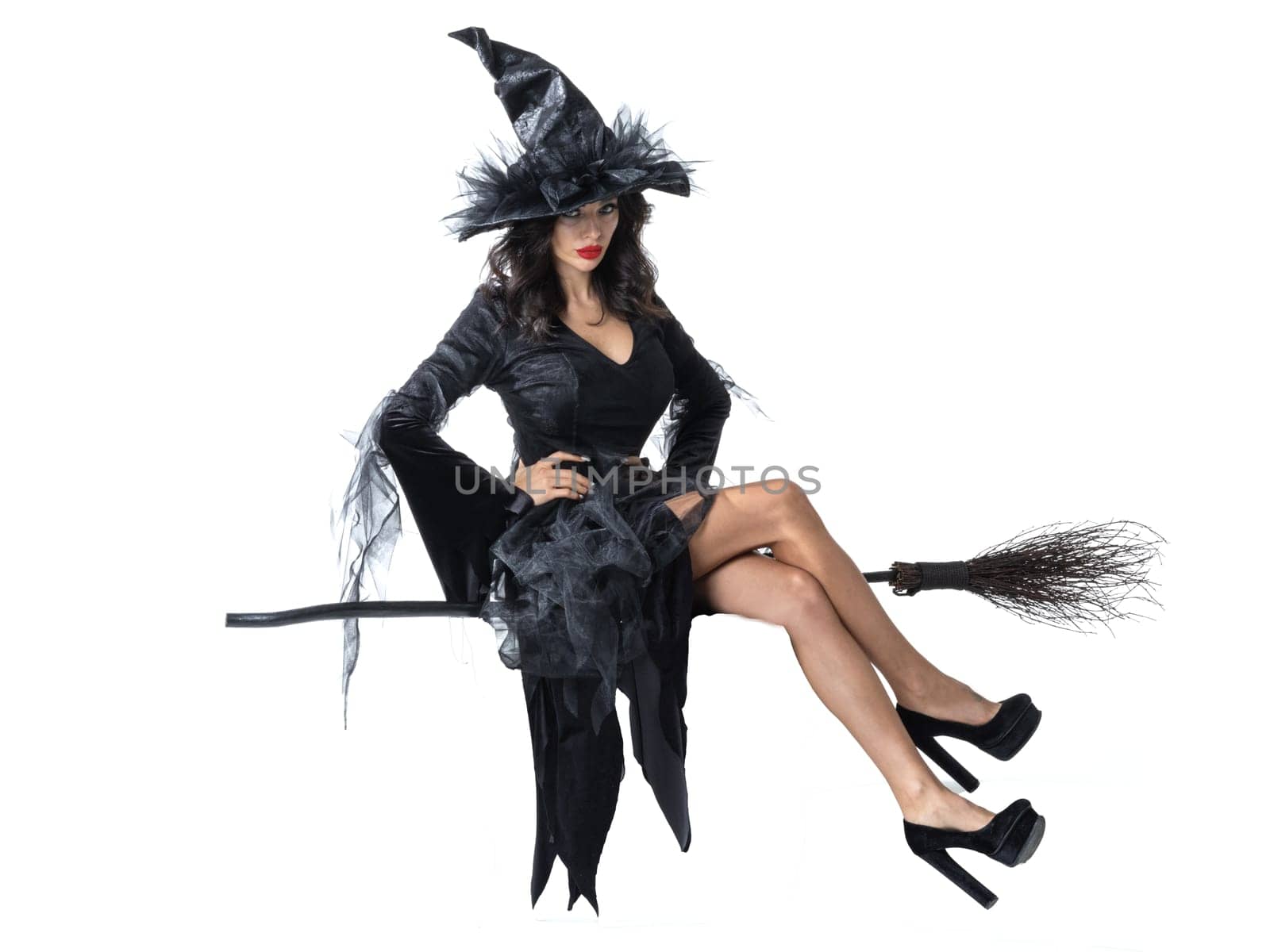 Halloween witch flying on broom studio isolated on white background design element. Beautiful sexy model woman in costume and make up