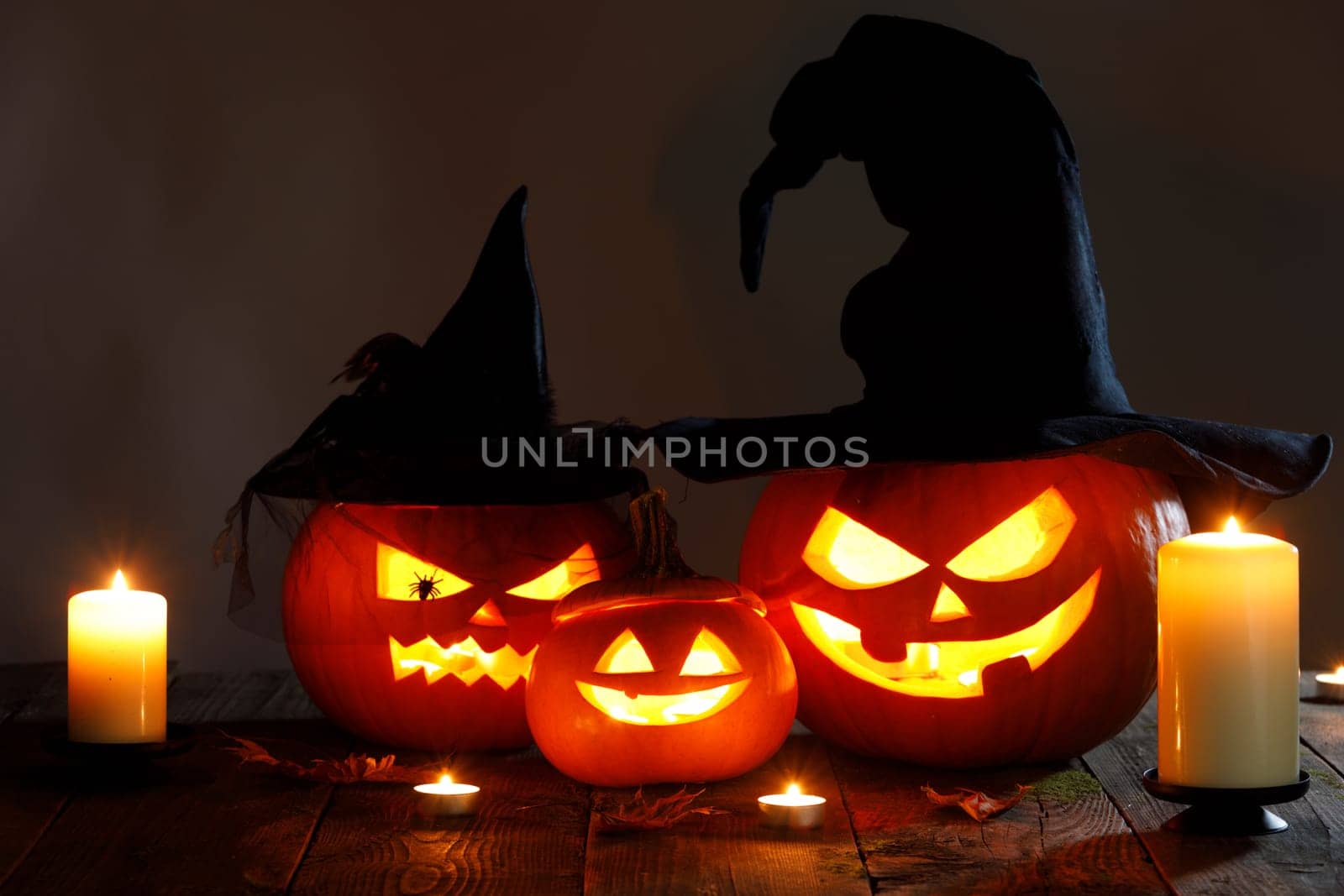 Still life of Halloween pumpkin lanterns pumpkins and hats decoration in candle light