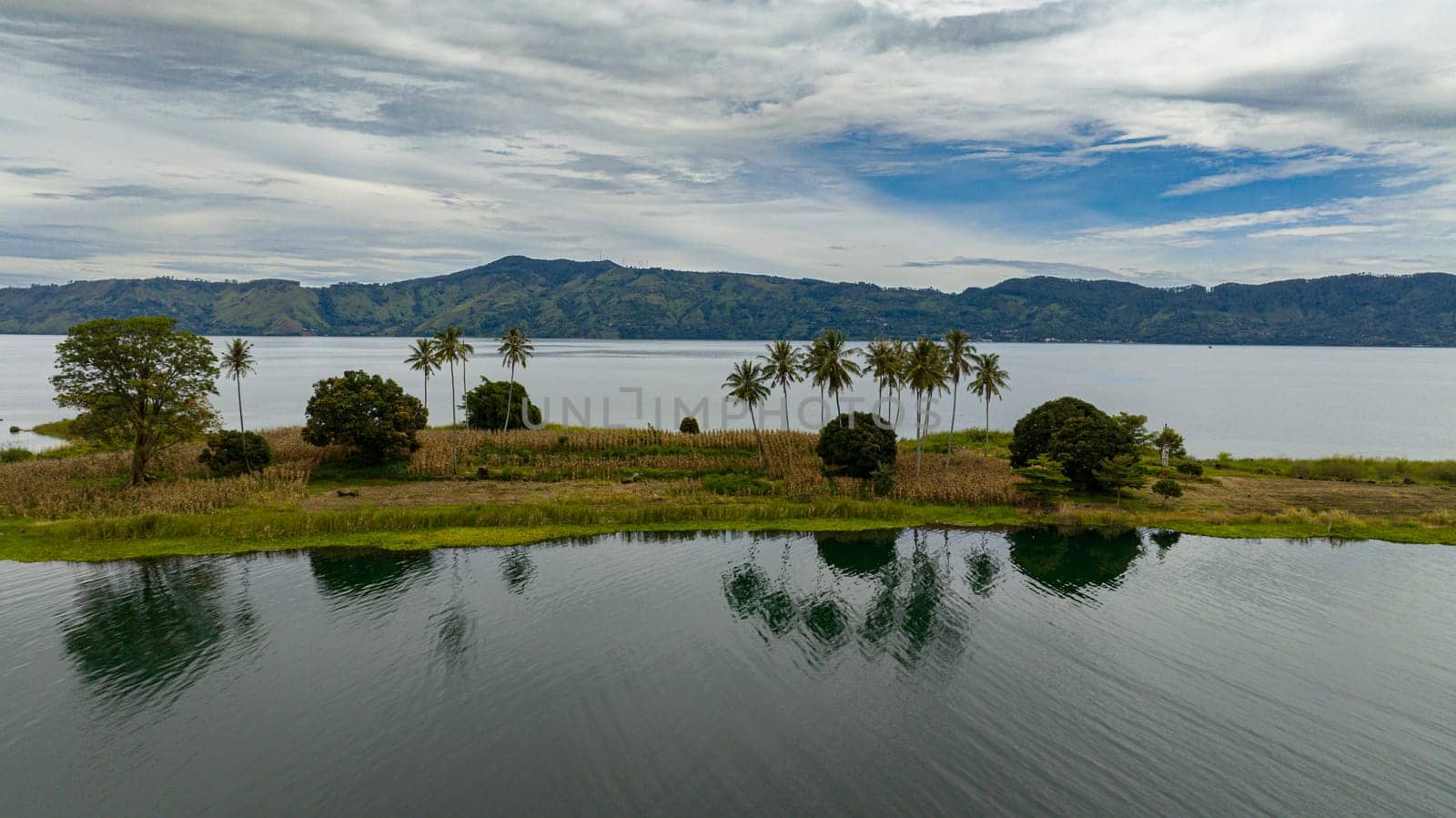 Aerial view of beautiful Lake Toba and an island with palm trees. Samosir, Pulau Toba. Sumatra, Indonesia.