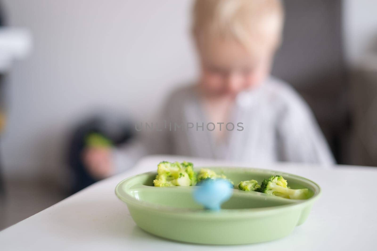 Caucasian little girl eats vegetable salad made from broccoli