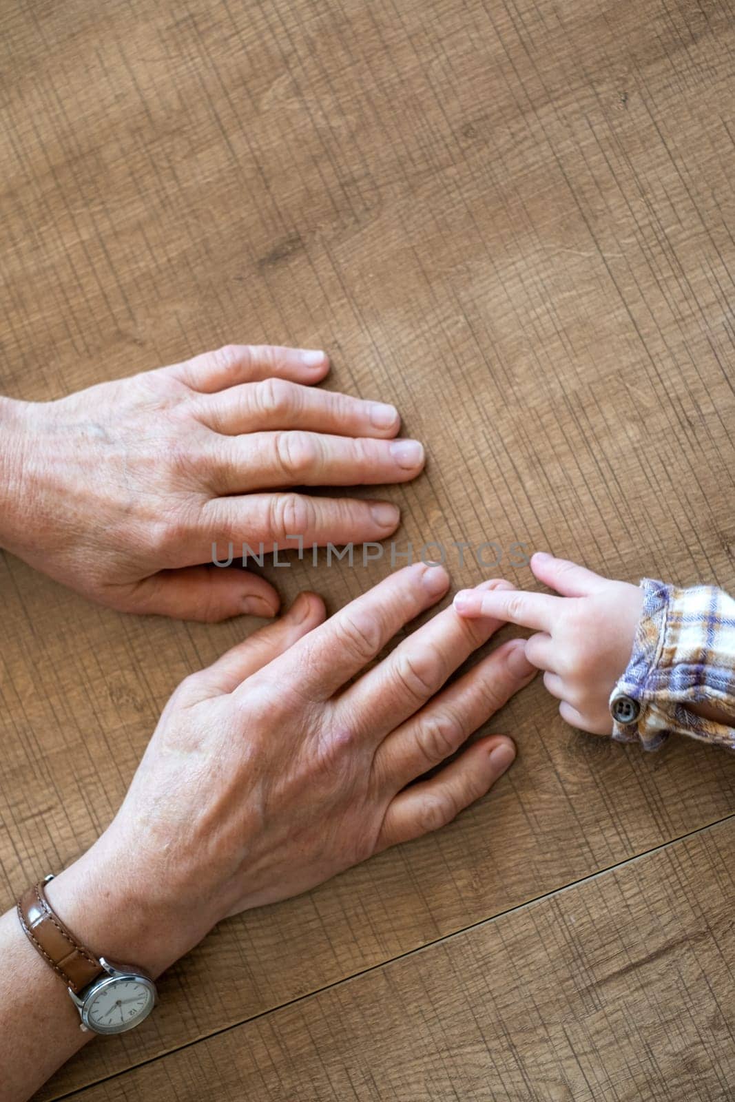 Old female hand holding young baby hand. High quality photo