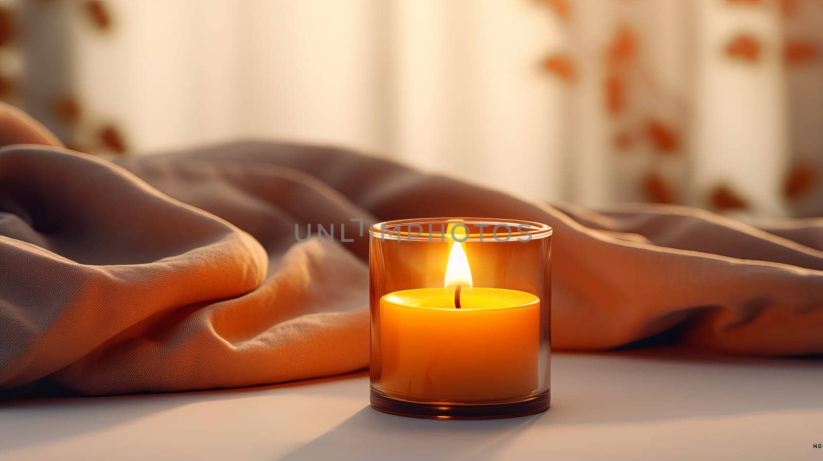 A lit candle sitting on top of a blanket.