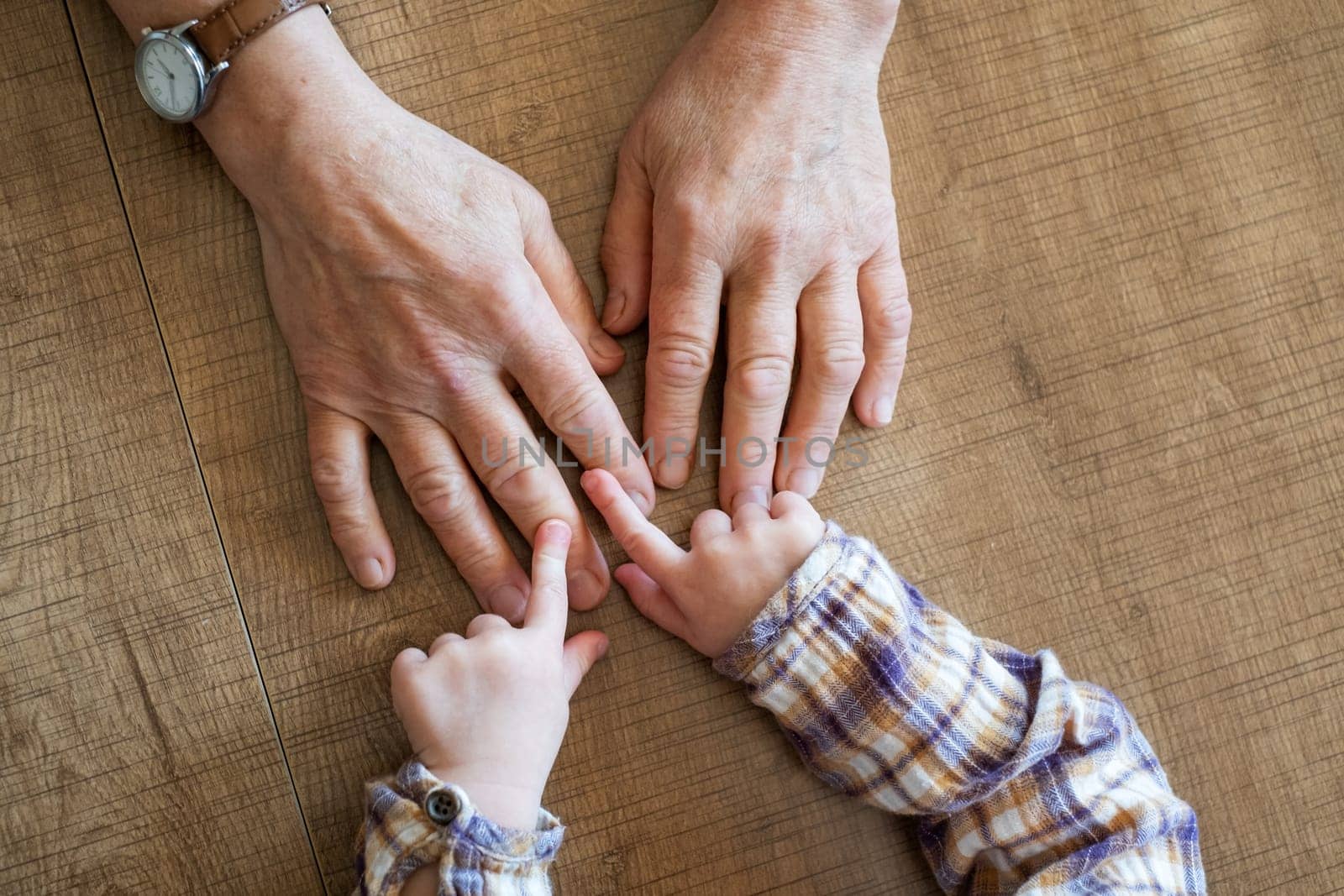 Old female hand holding young baby hand. High quality photo