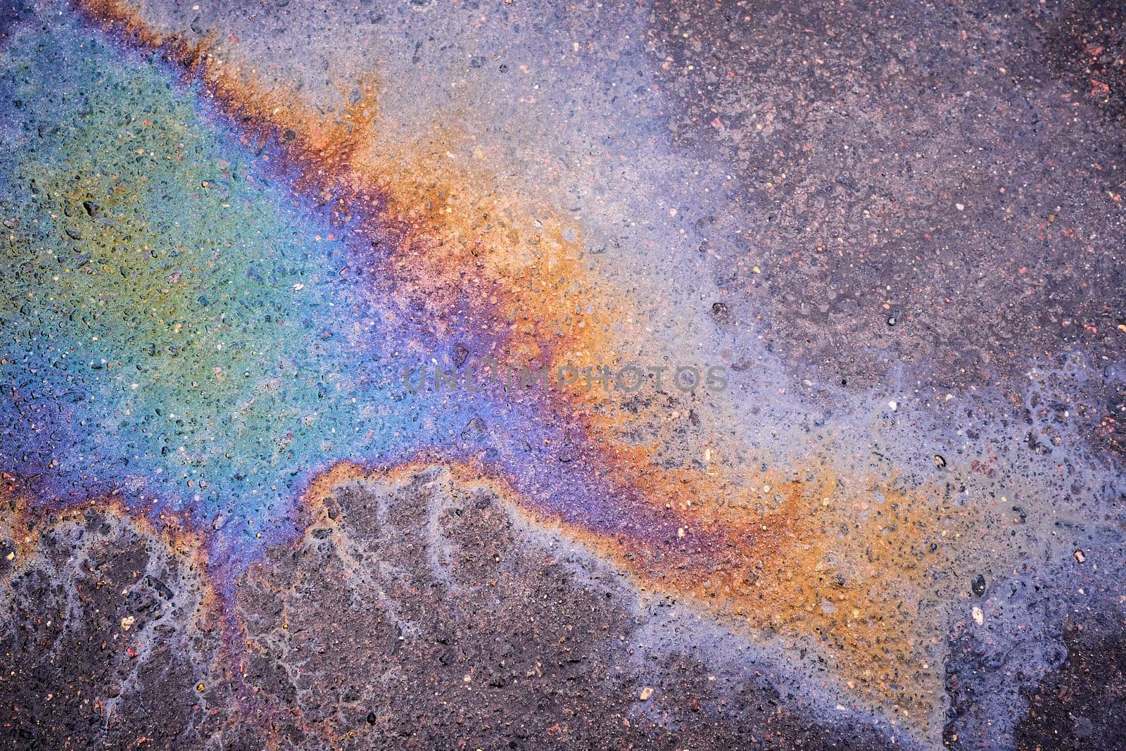 Captivating close-up of the opalescent sheen of a petrochemical spill on saturated asphalt