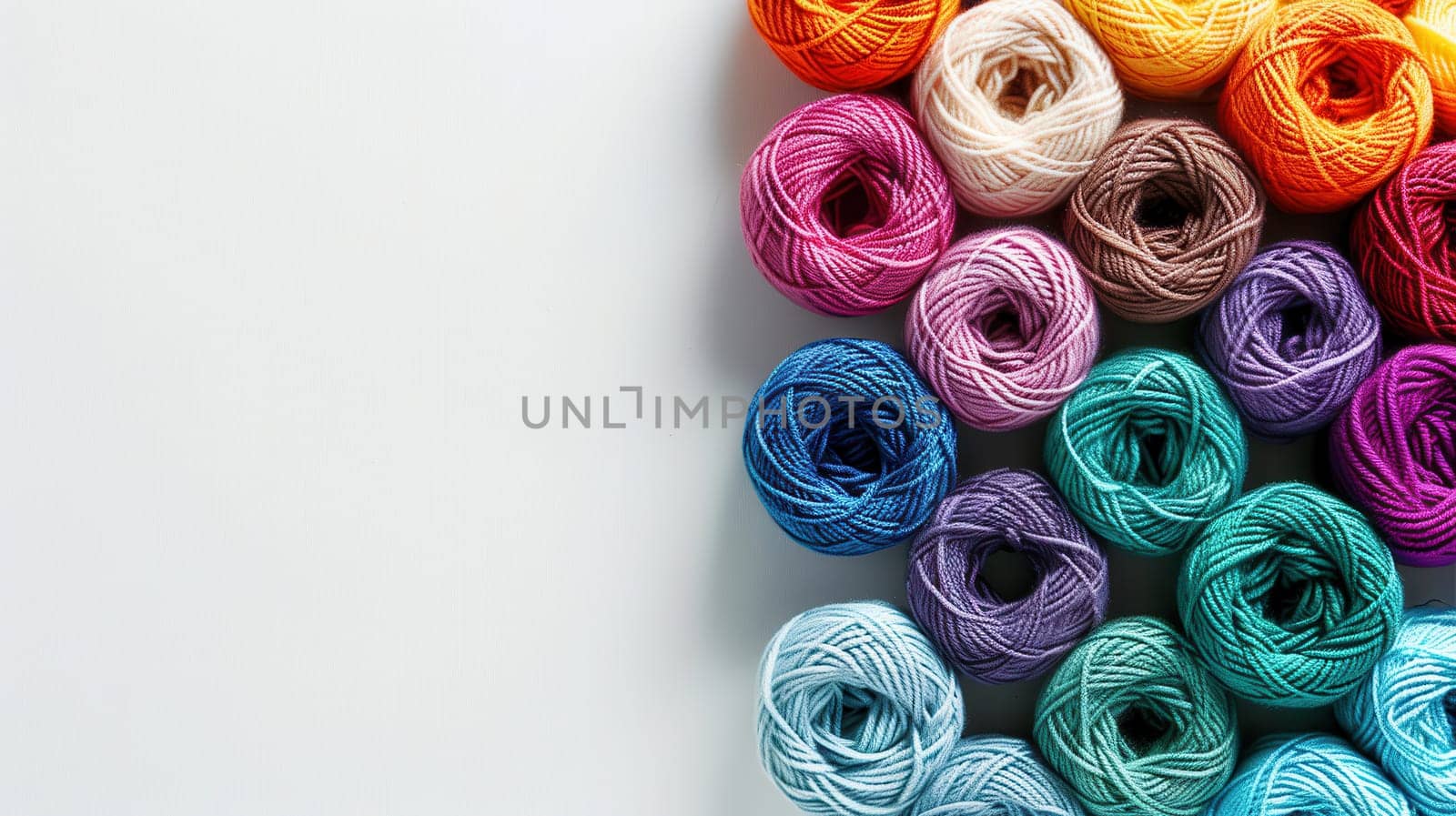 Colorful yarn rolls are neatly arranged in a grid style, showcasing vibrant hues against a clean white background, perfect for text overlay and crafting inspiration.