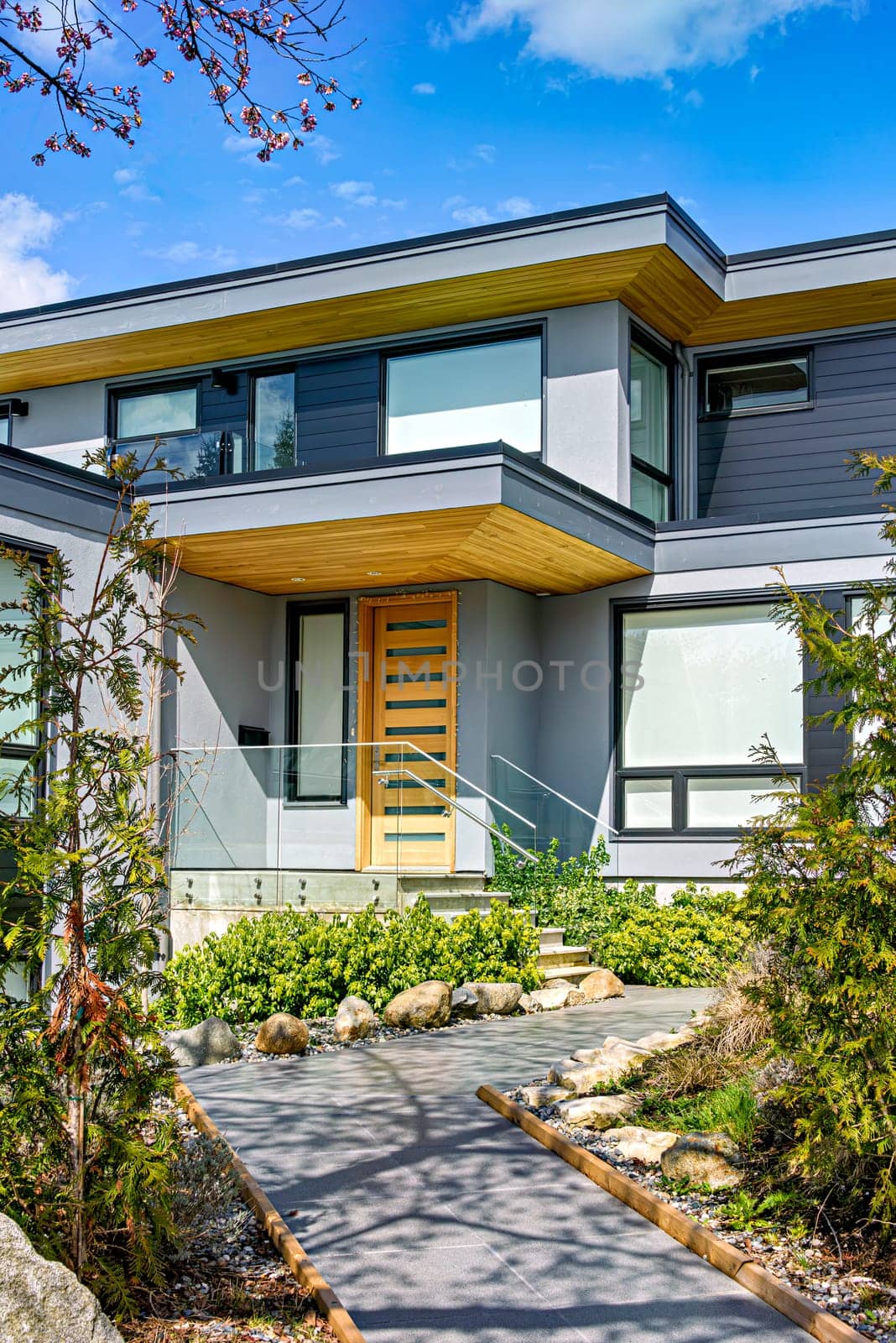 Neat entrance of modern residential house on blue sky background.