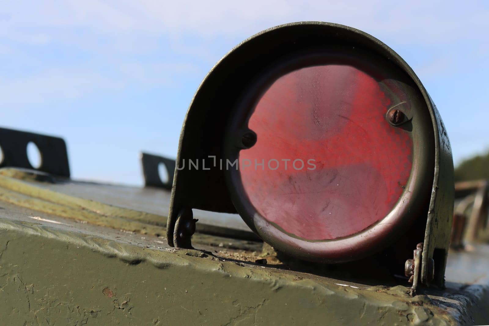Close-up of special red illuminator on green military equipment.