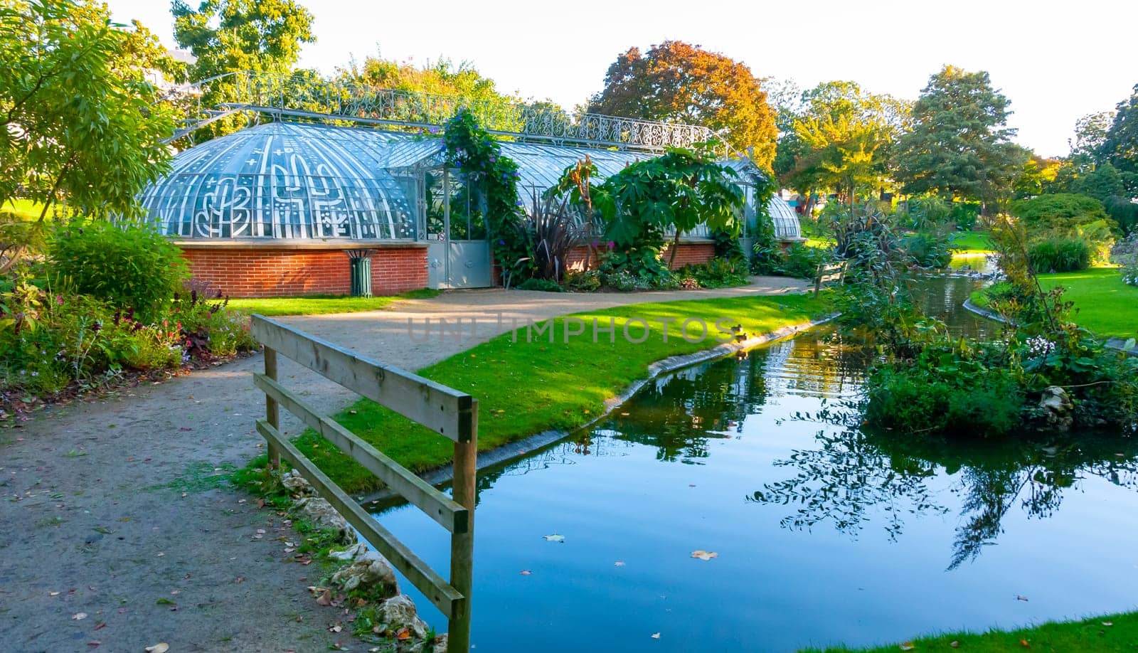 NANTES, FRANCE - SEPTEMBER 12, 2017: An original greenhouse near an artificial lake in a botanical garden in Nantes, France