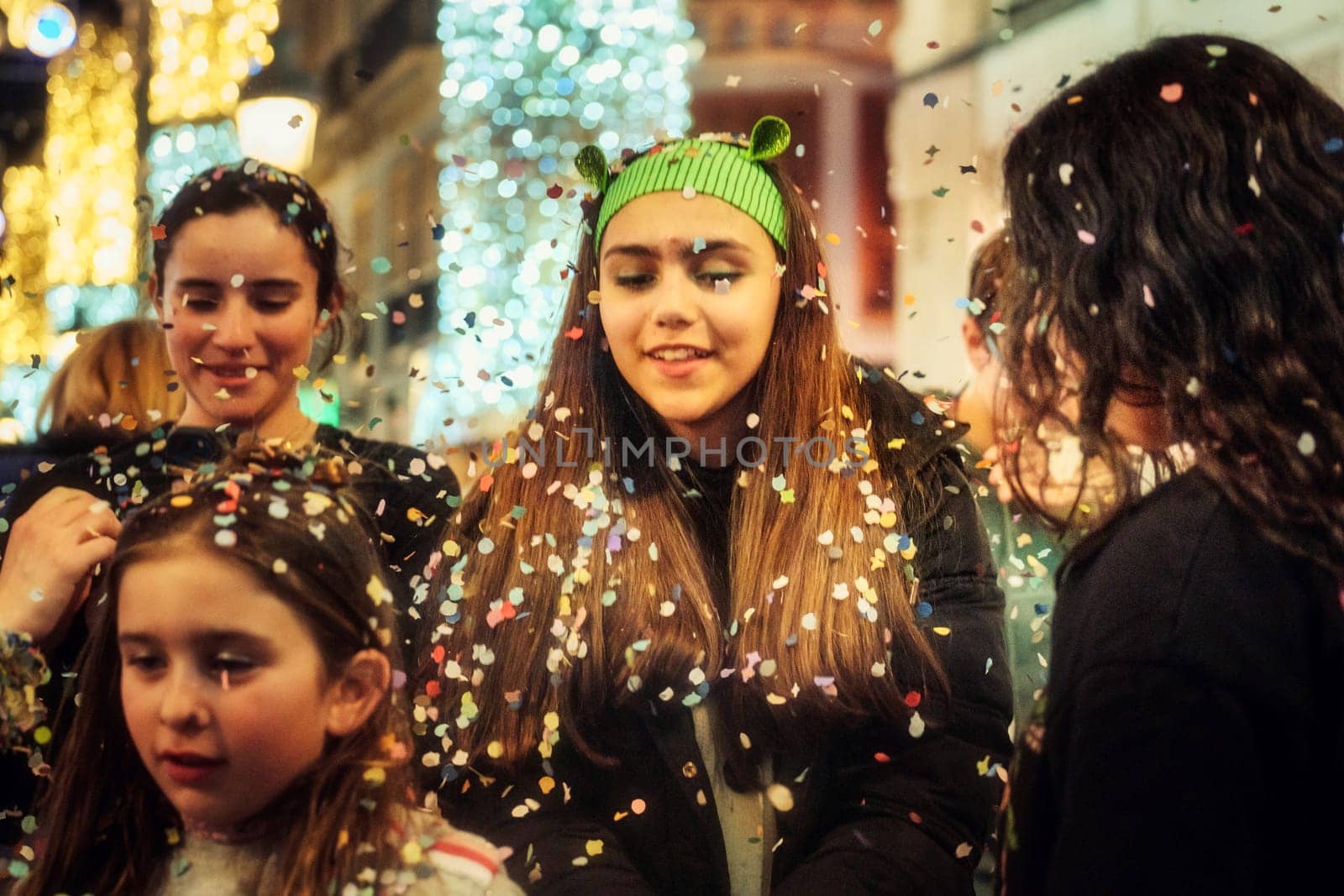 group of people, enjoying a festive moment with confetti floating in the air around them. The atmosphere appears to be joyous, as if they might be celebrating a special occasion or participating in a public festivity.