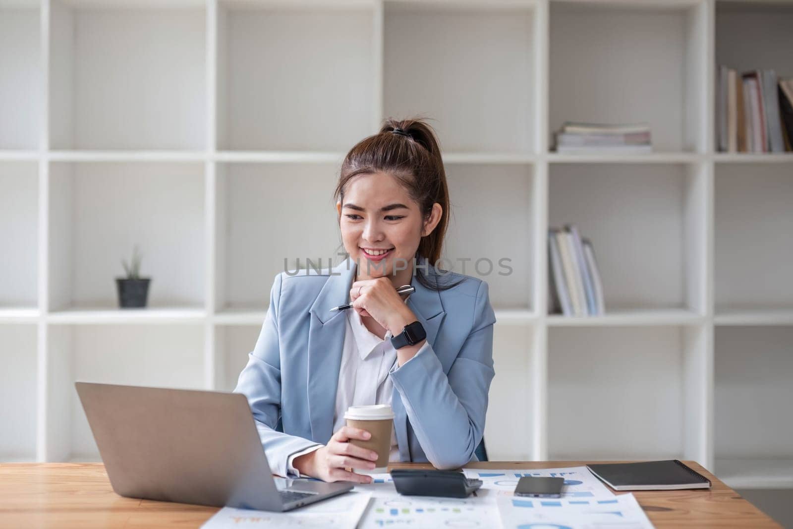 Asian businesswoman use laptop computer in office The Internal Revenue Service audit document balance calculation report is being prepared..