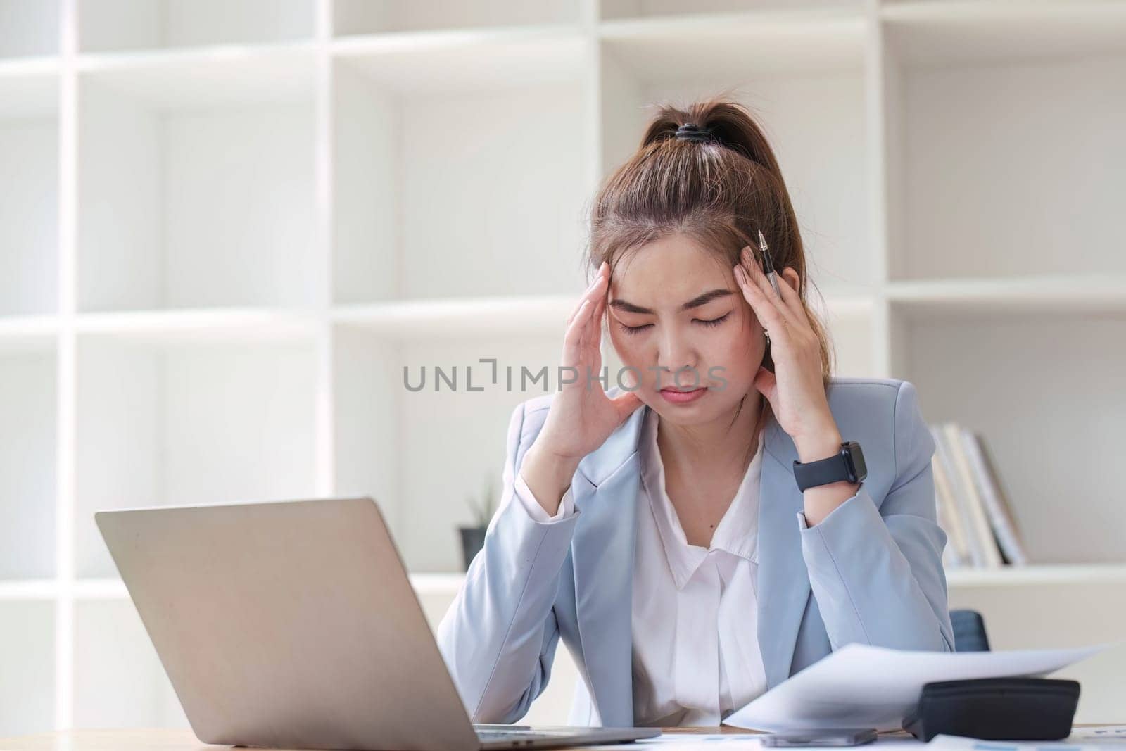 Confused Asian woman thinking hard about how to solve problems online looking at laptop screen. Serious Asian businesswoman worried focused on solving difficult computer at office.