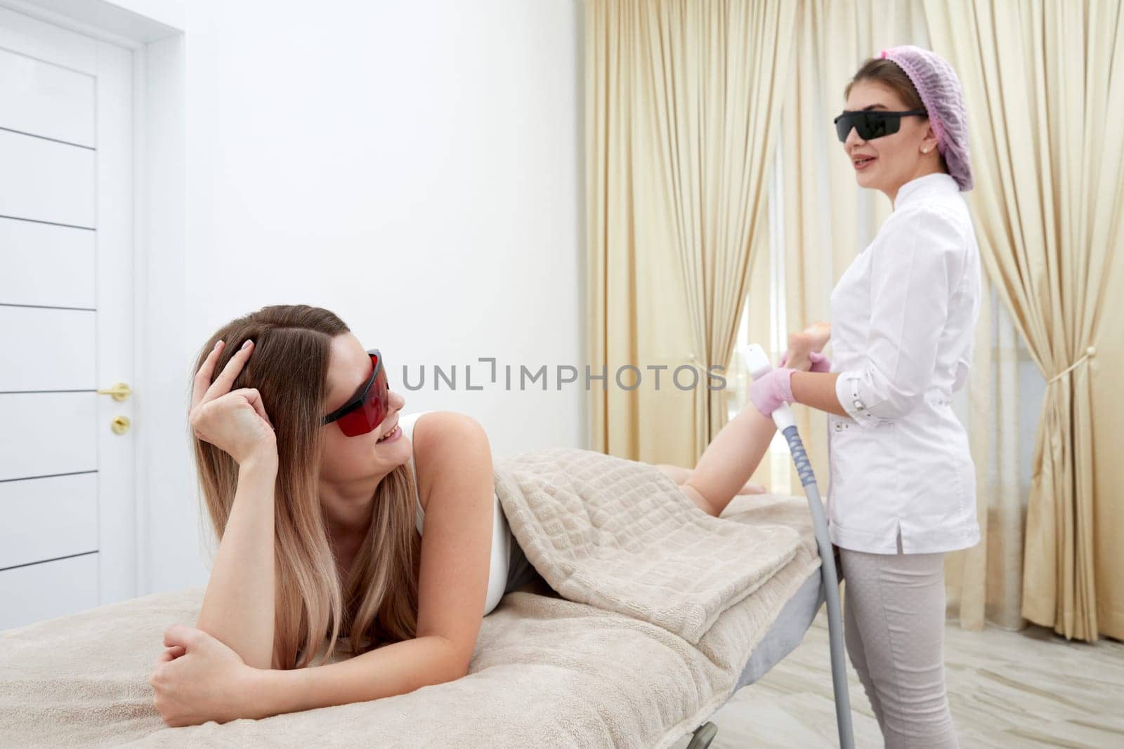 Young woman at a beauty salon undergoing laser hair removal on her legs