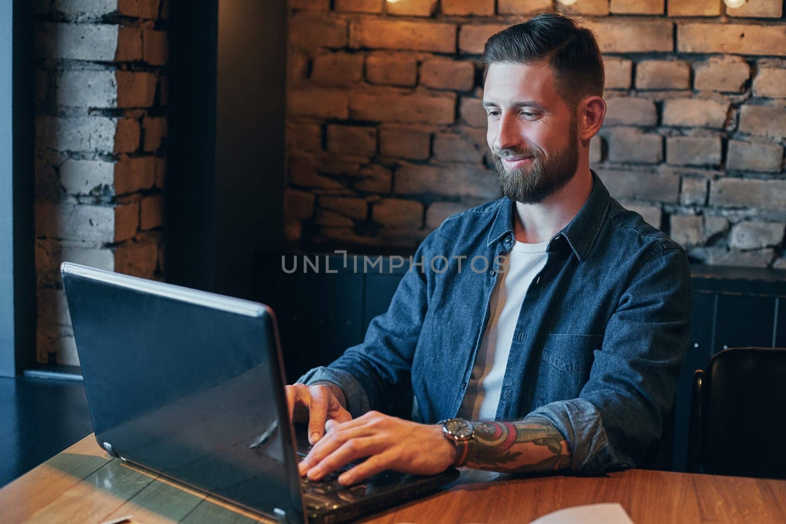 No minute without my laptop. Handsome young man working on laptop while enjoying coffee in cafe.