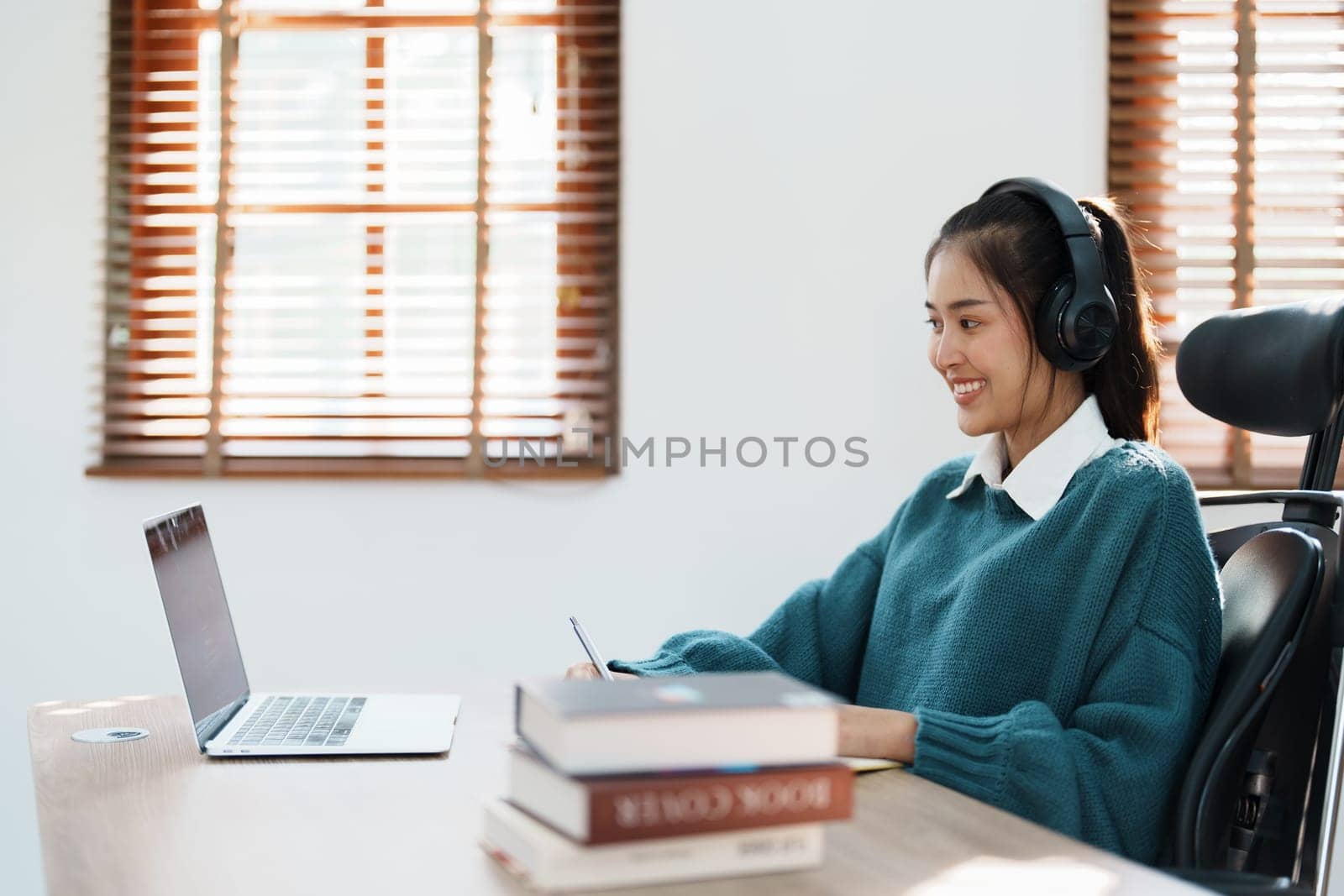 Studying online, beautiful Asian female student or student studying online at home by Manastrong