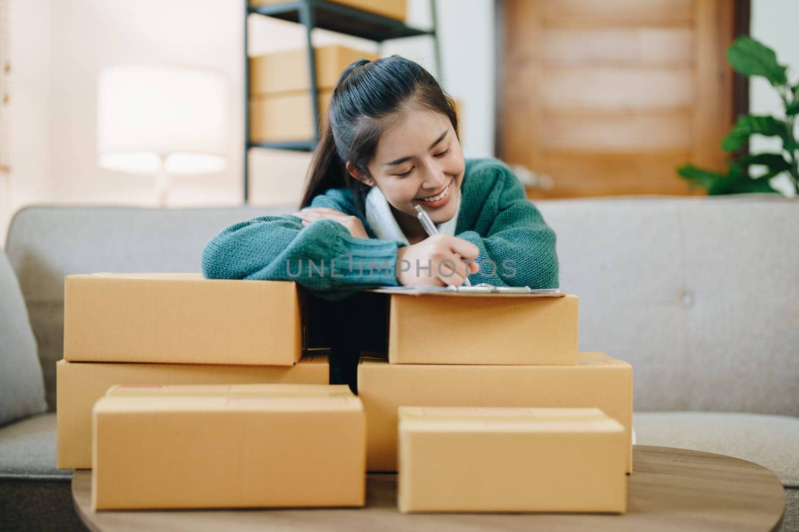 Starting small business entrepreneur of independent Asian female online seller packing products to send to customers and SME delivery concept by Manastrong