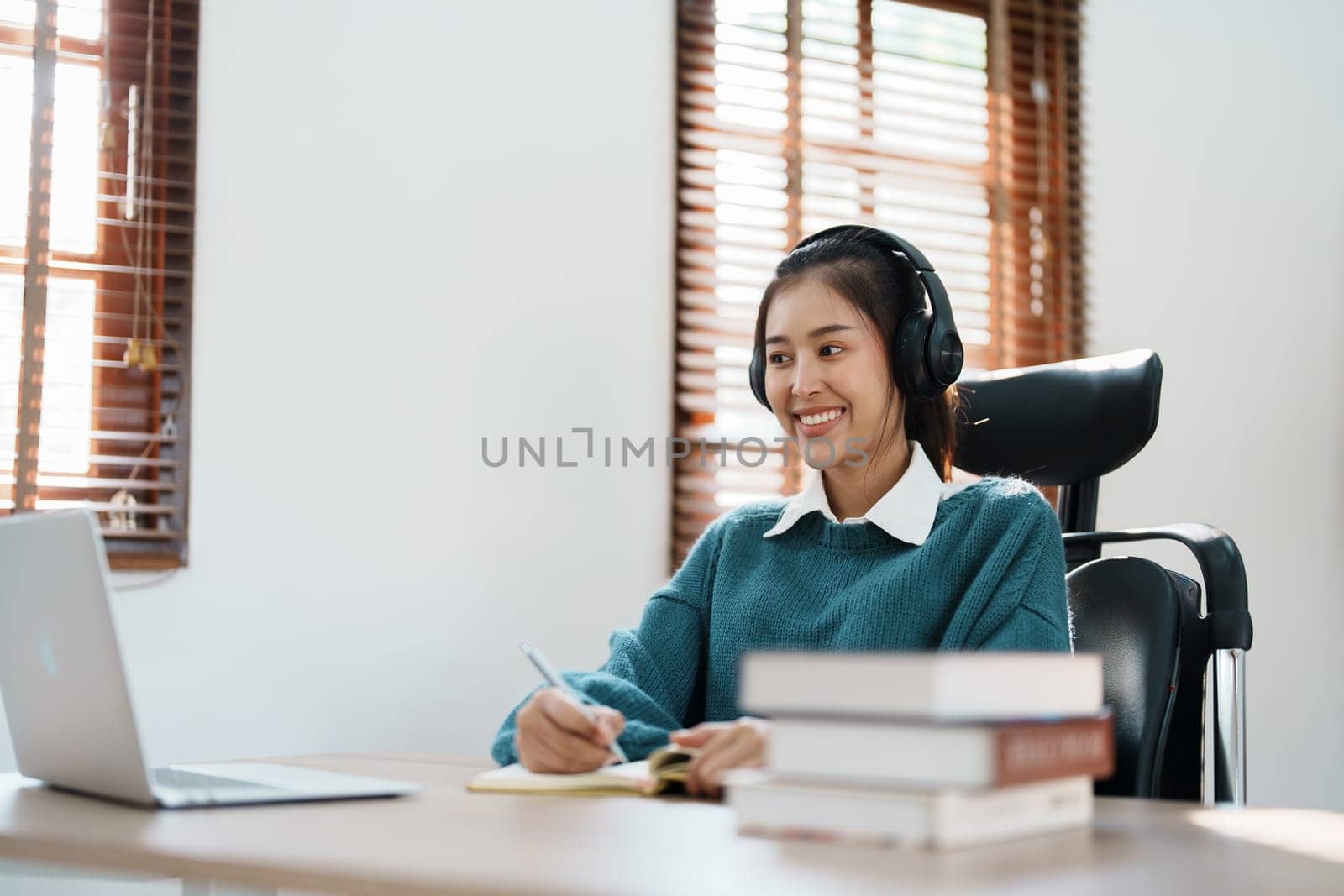 Studying online, beautiful Asian female student or student studying online at home by Manastrong