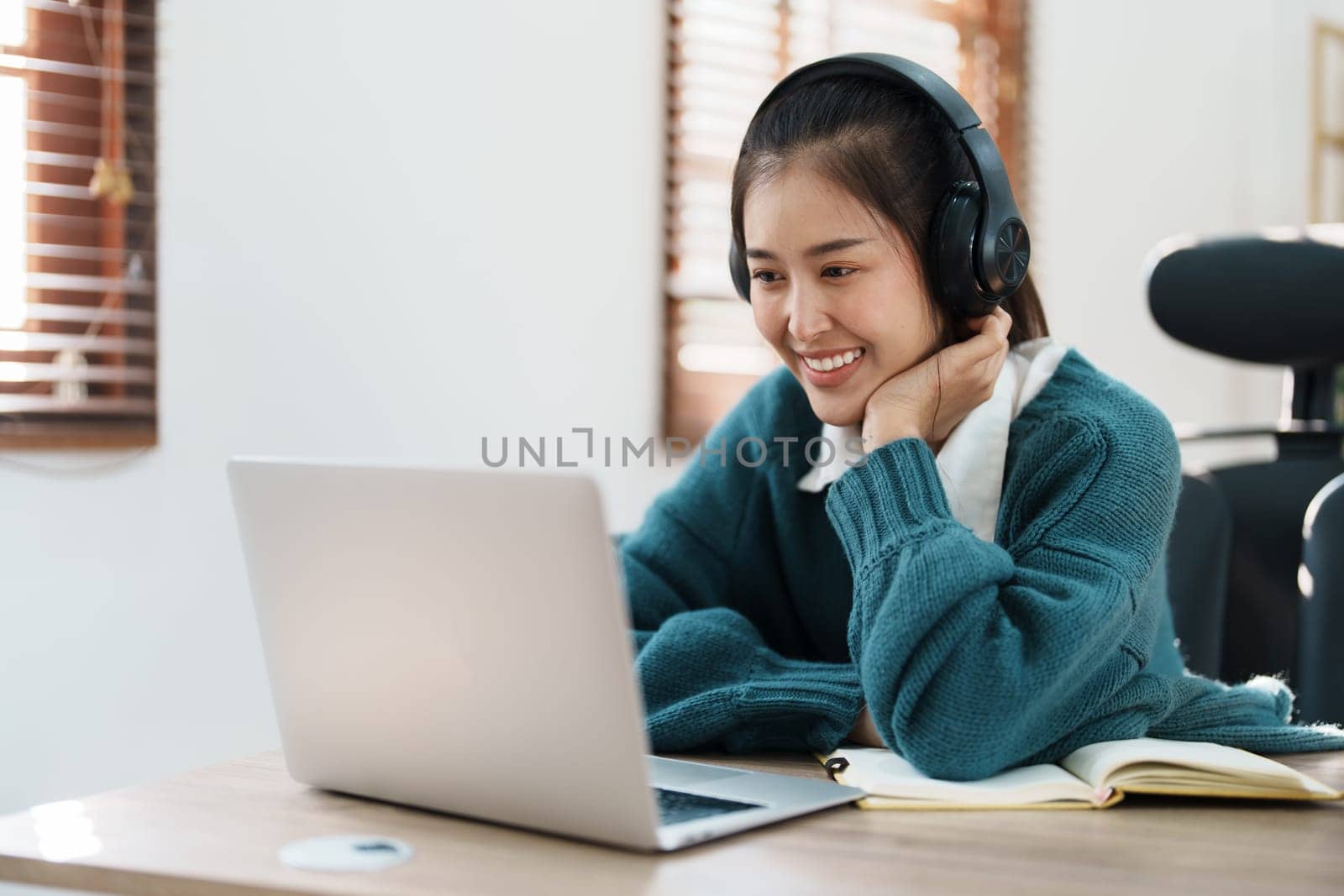 Studying online, beautiful Asian female student or student studying online at home by Manastrong