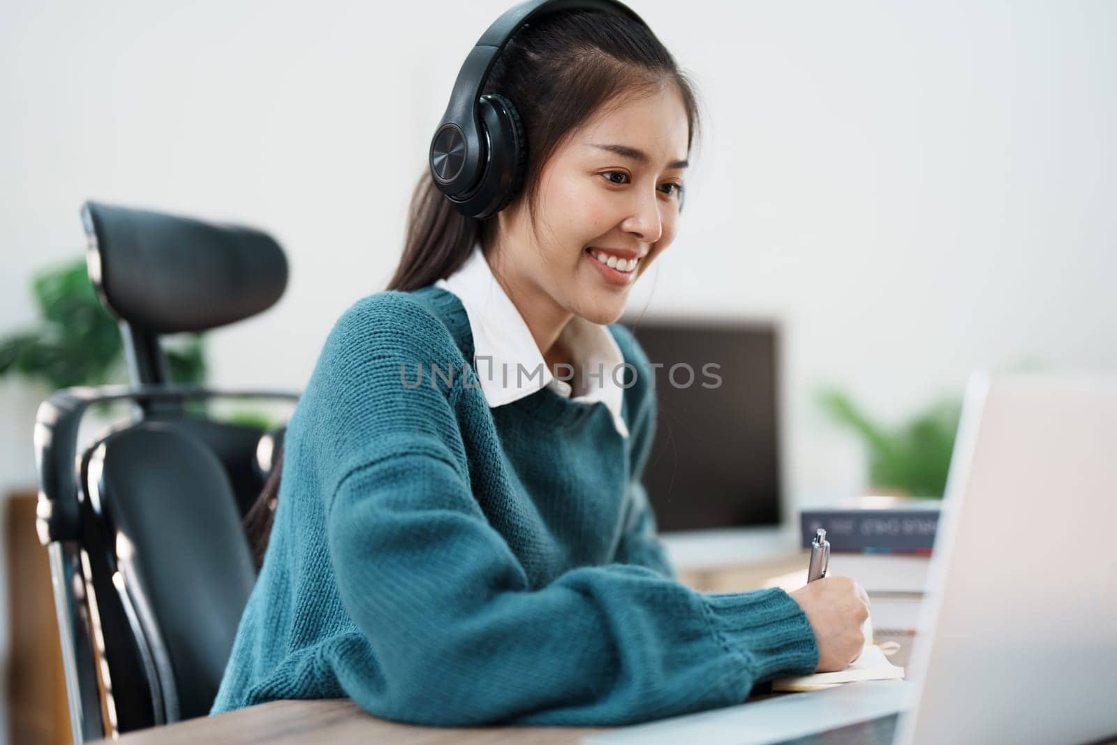 Studying online, beautiful Asian female student or student studying online at home by Manastrong