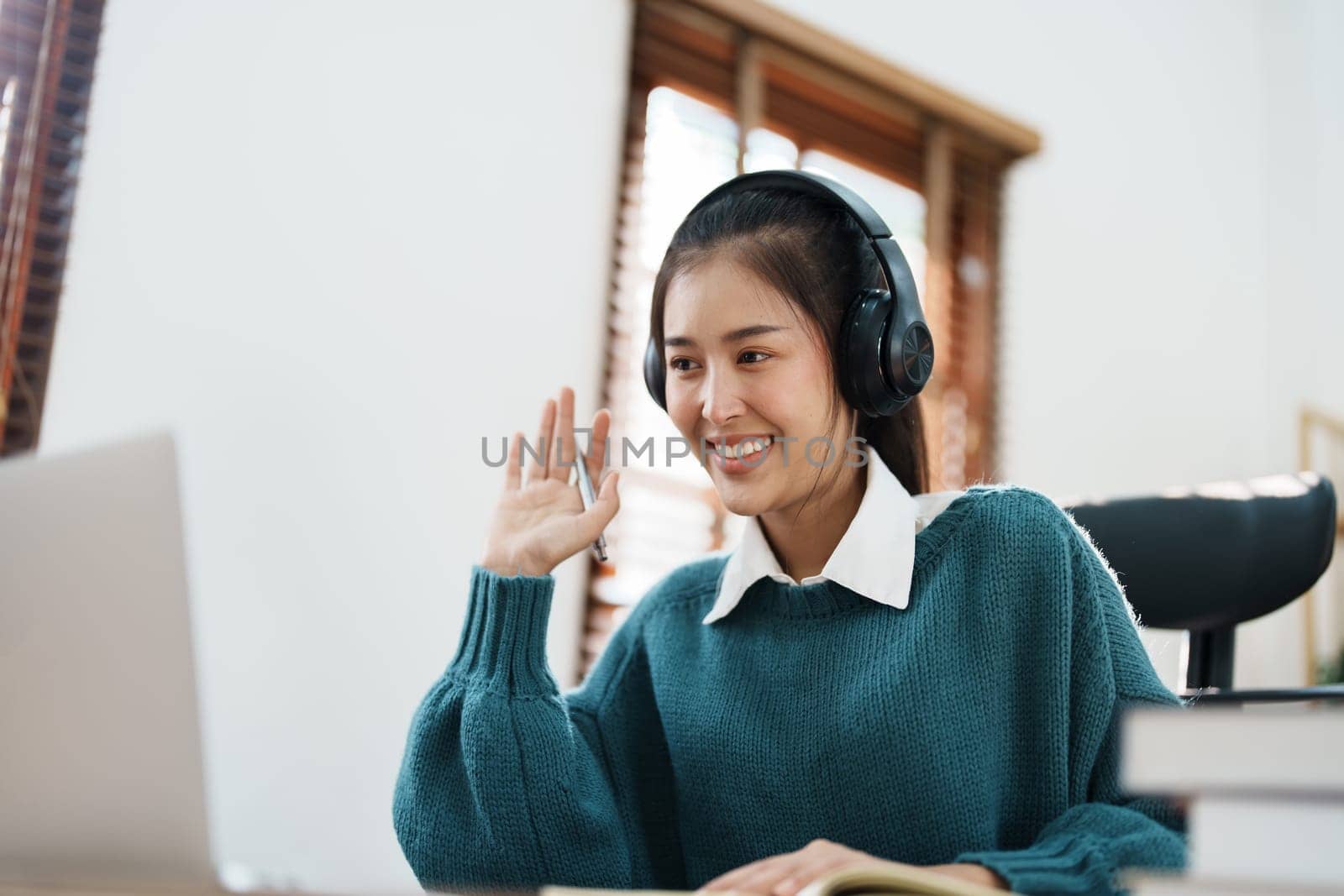 Studying online, beautiful Asian female student or student studying online at home by Manastrong