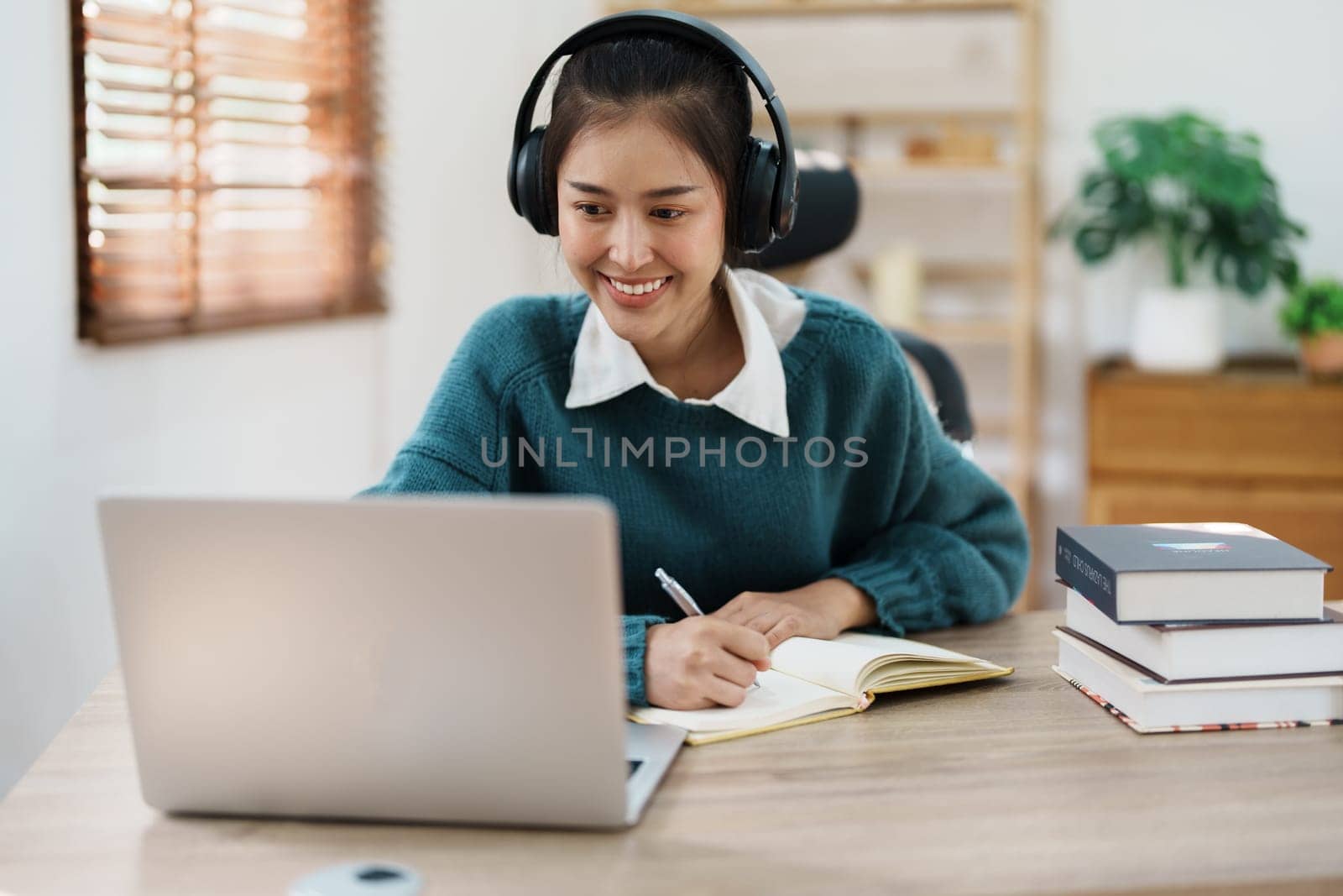 Studying online, beautiful Asian female student or student studying online at home by Manastrong