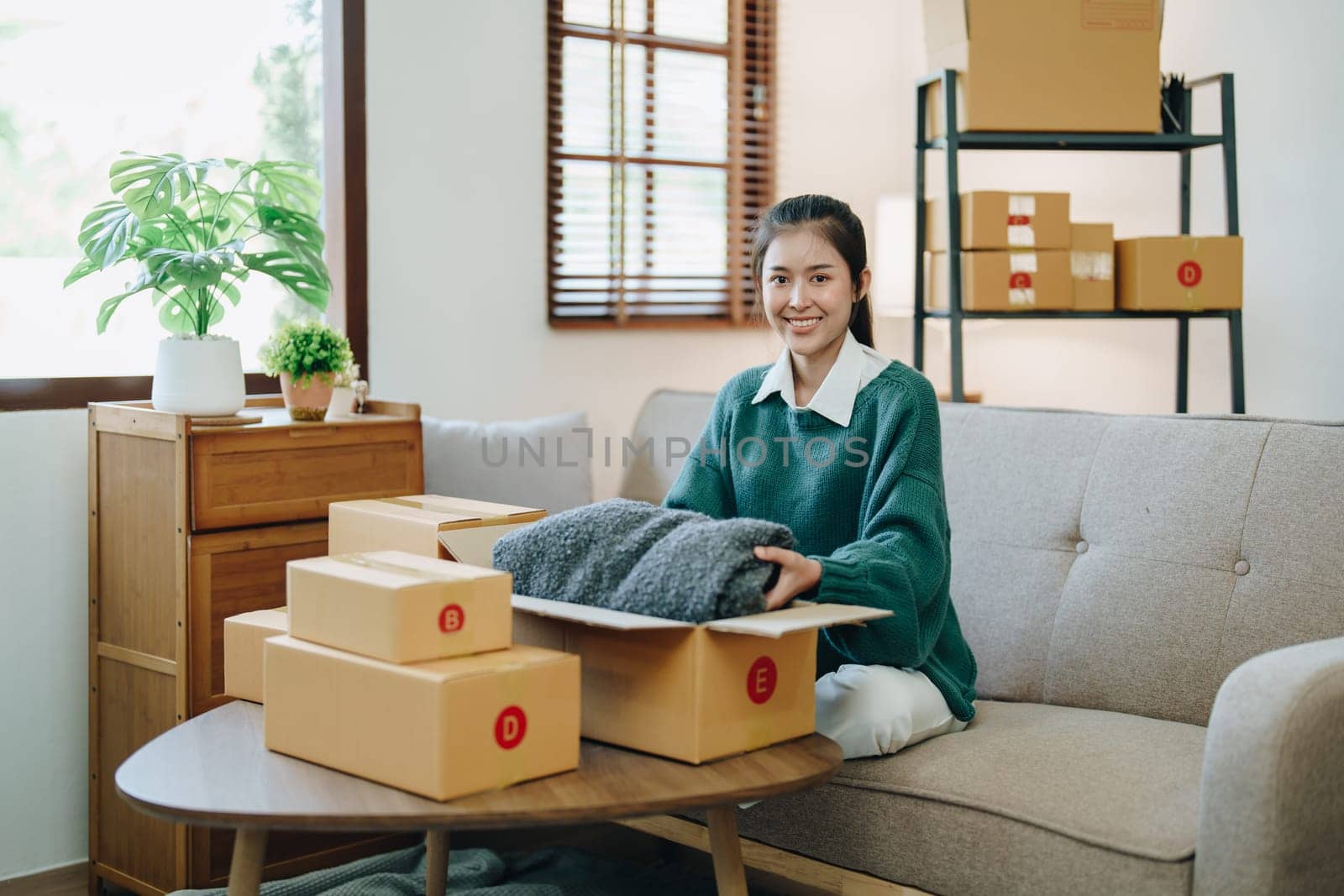 Starting small business entrepreneur of independent Asian female online seller packing products to send to customers and SME delivery concept by Manastrong