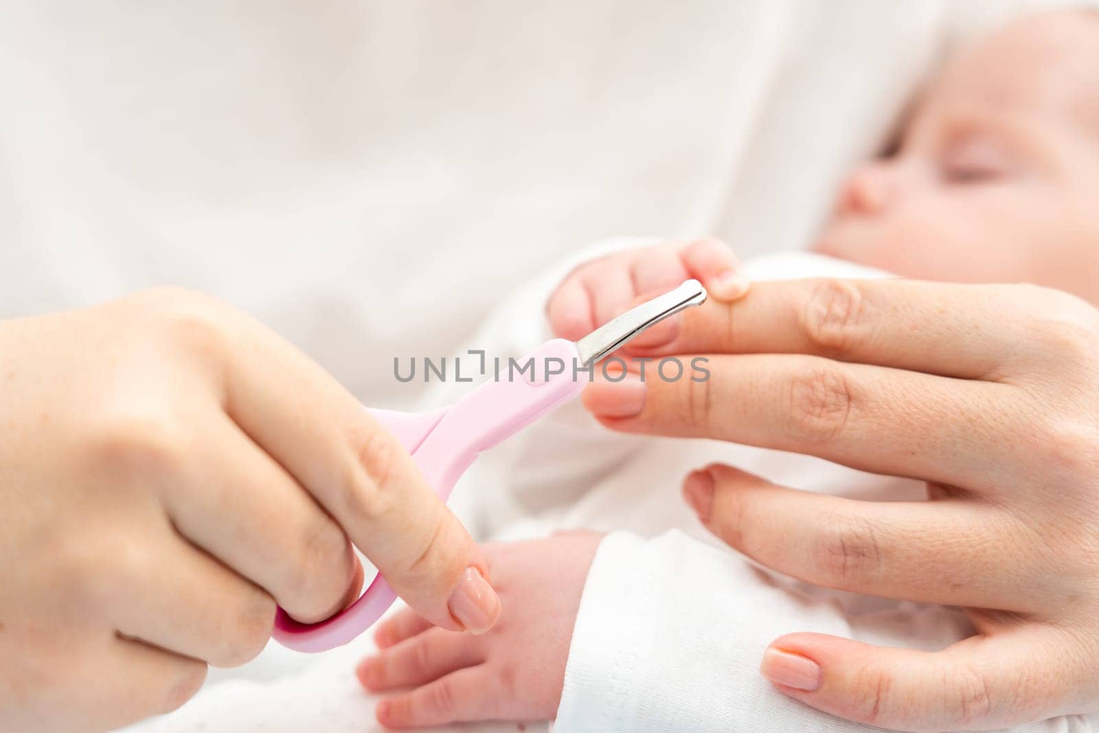 With close-up precision, a mother ensures every nail of her newborn is cut safely and meticulously