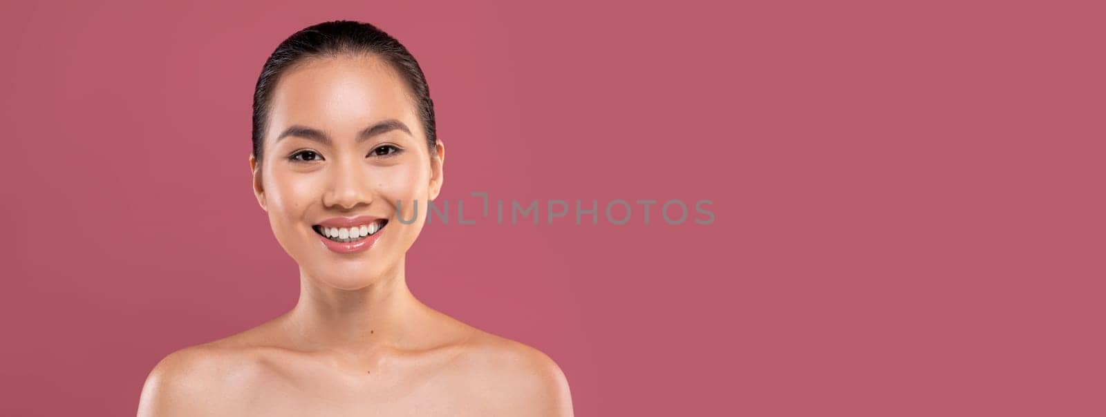 Portrait of attractive naked young japanese lady posing on purple studio background, cheerfully smiling at camera, copy space. Skin and body care for young women, healthy lifestyle concept