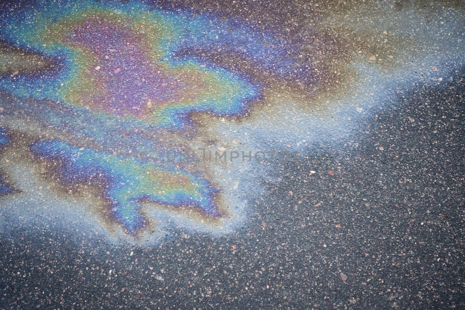 Leaks of automotive fluids on the asphalt pavement creating an interesting visual base