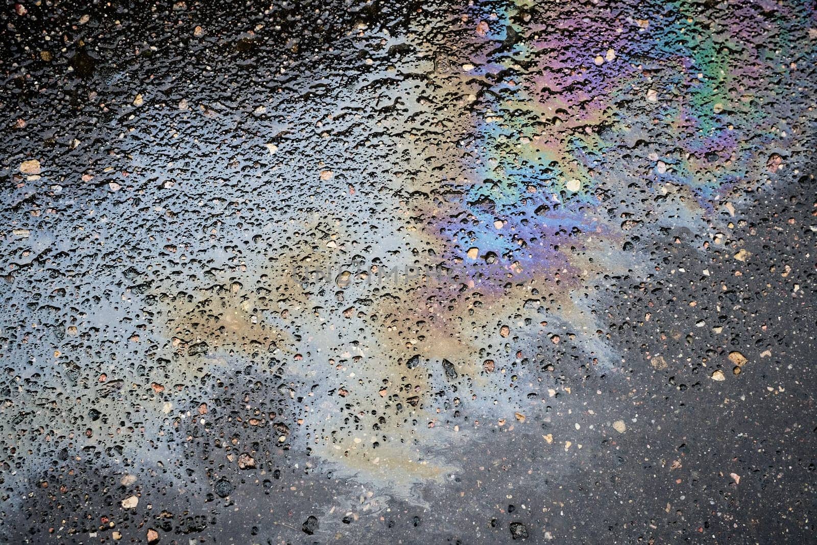 Patterns of Vibrant Oil Slicks on Rain-soaked Asphalt.