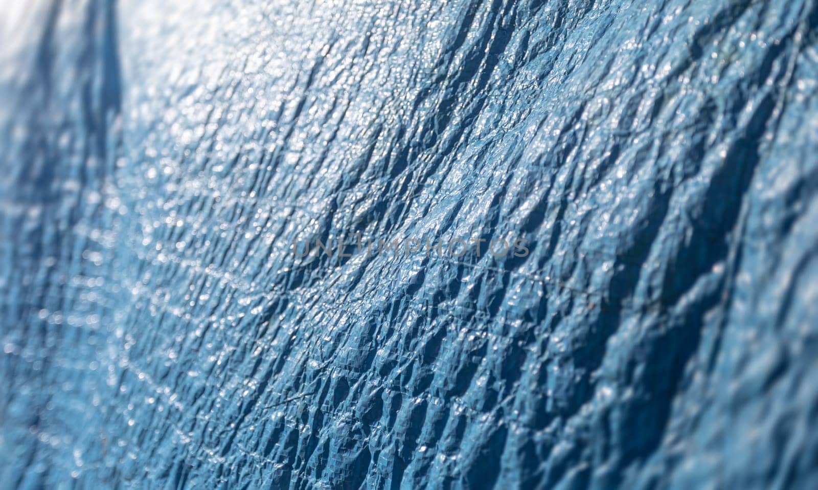 Plastic blue protective film covering construction materials. Abstract background and texture.