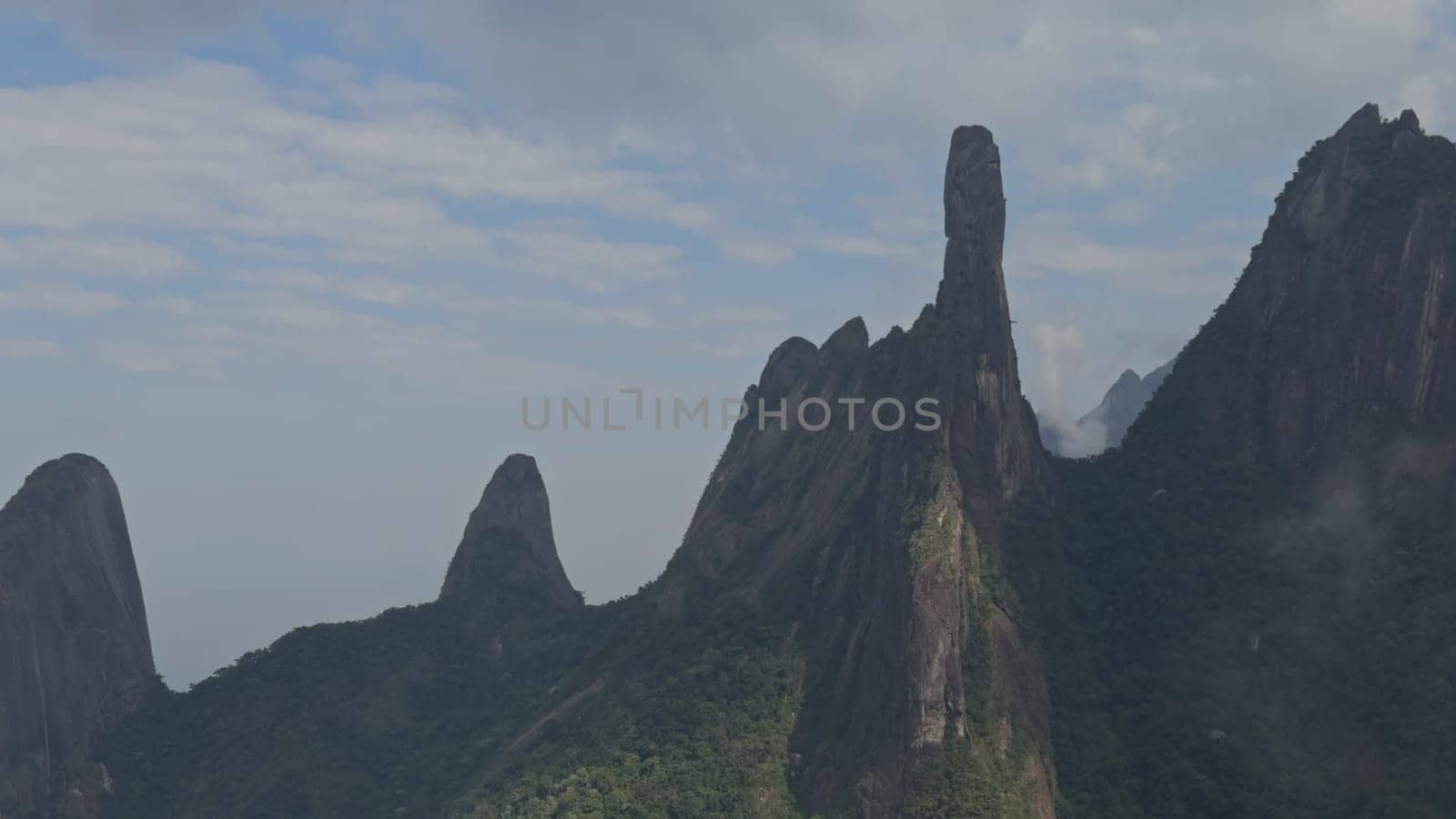Video showcasing dramatic rock formations in lush jungle mountains shrouded in mist and clouds.