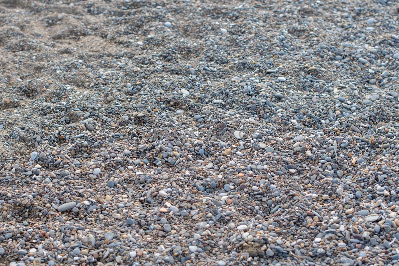 Gray small stones on sea pebble beach in Turkey, texture of stones, pebble surfaces,