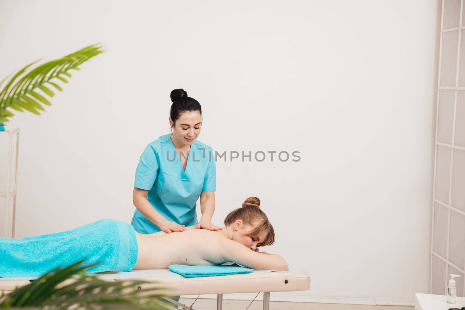 massage therapist does back massage to woman in the office osteopathy healthy back