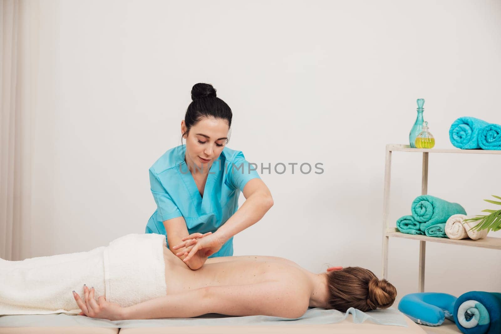 woman massage therapist makes client lower back massage relaxation relaxation osteopathy