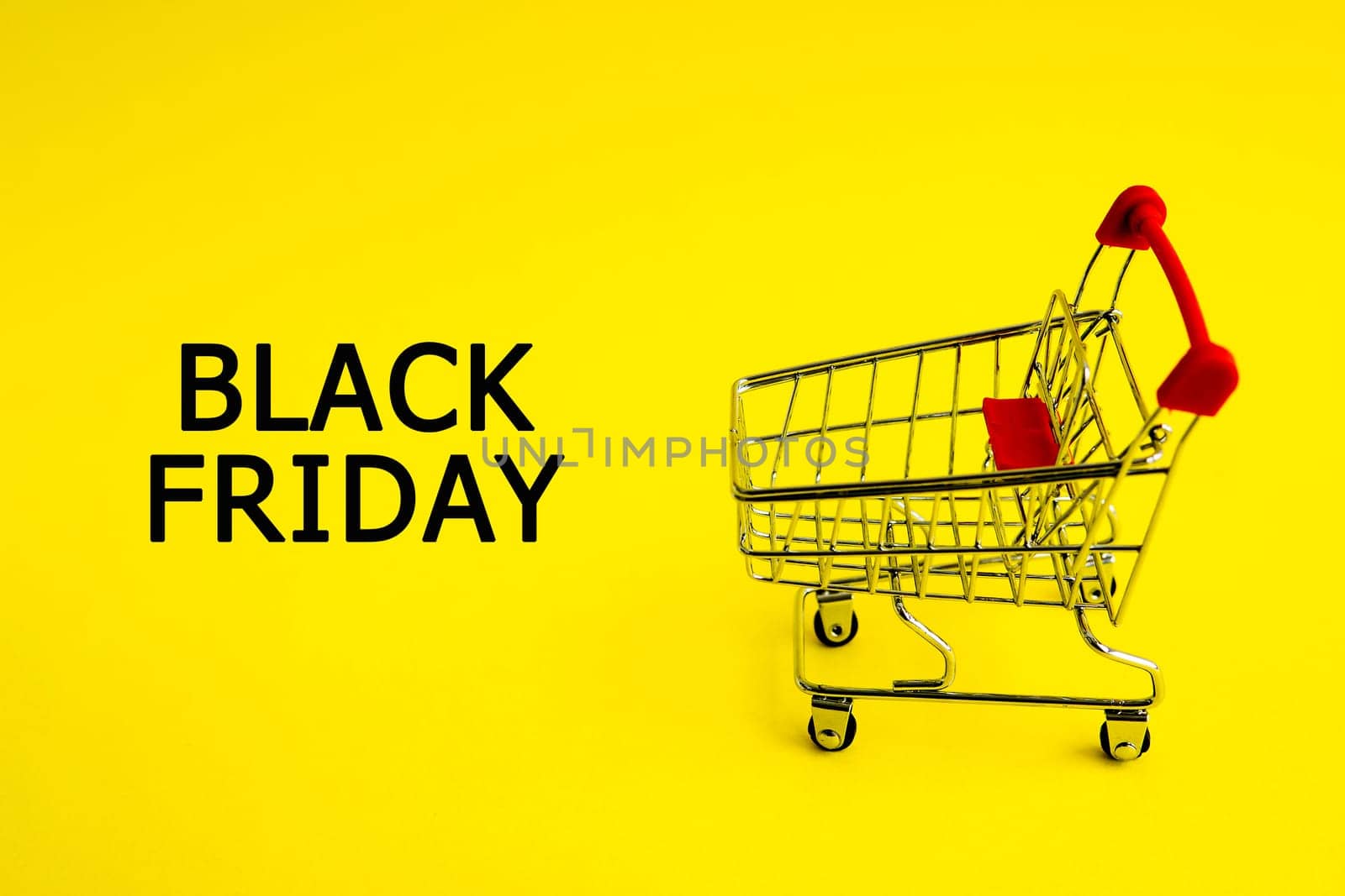 The shopping cart and the words black Friday on a yellow background. Theme of purchases and sales.