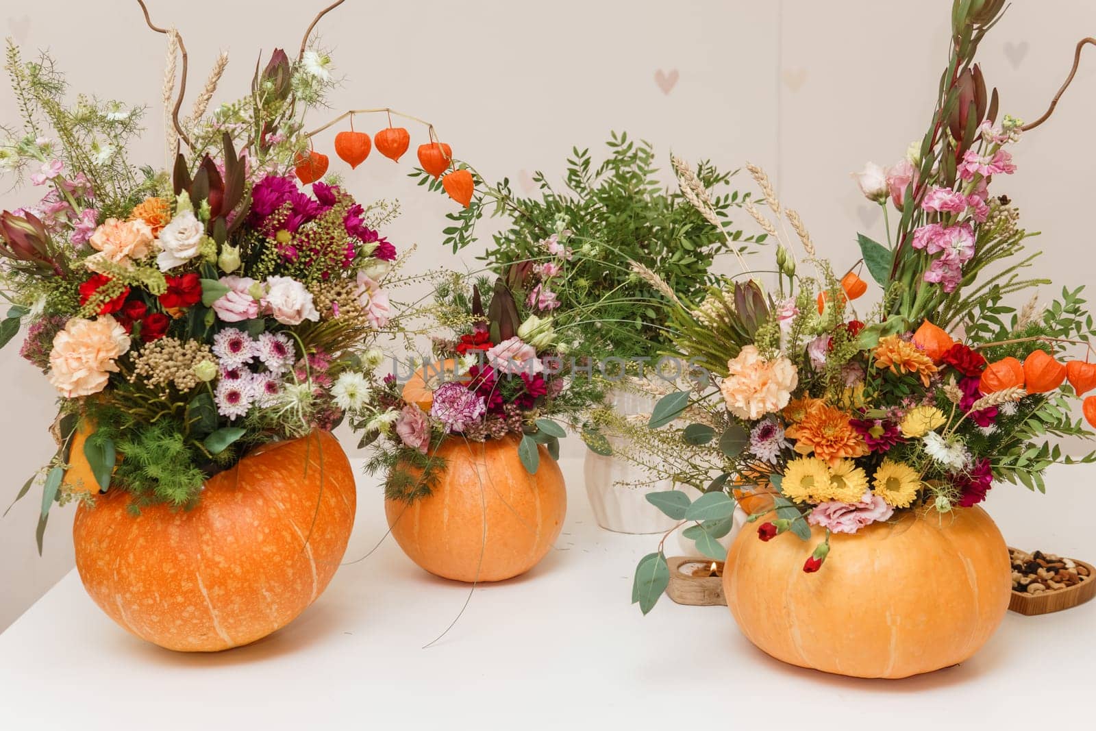 Flower arrangement in a pumpkin, autumn interior decor. Creating handmade autumn decor