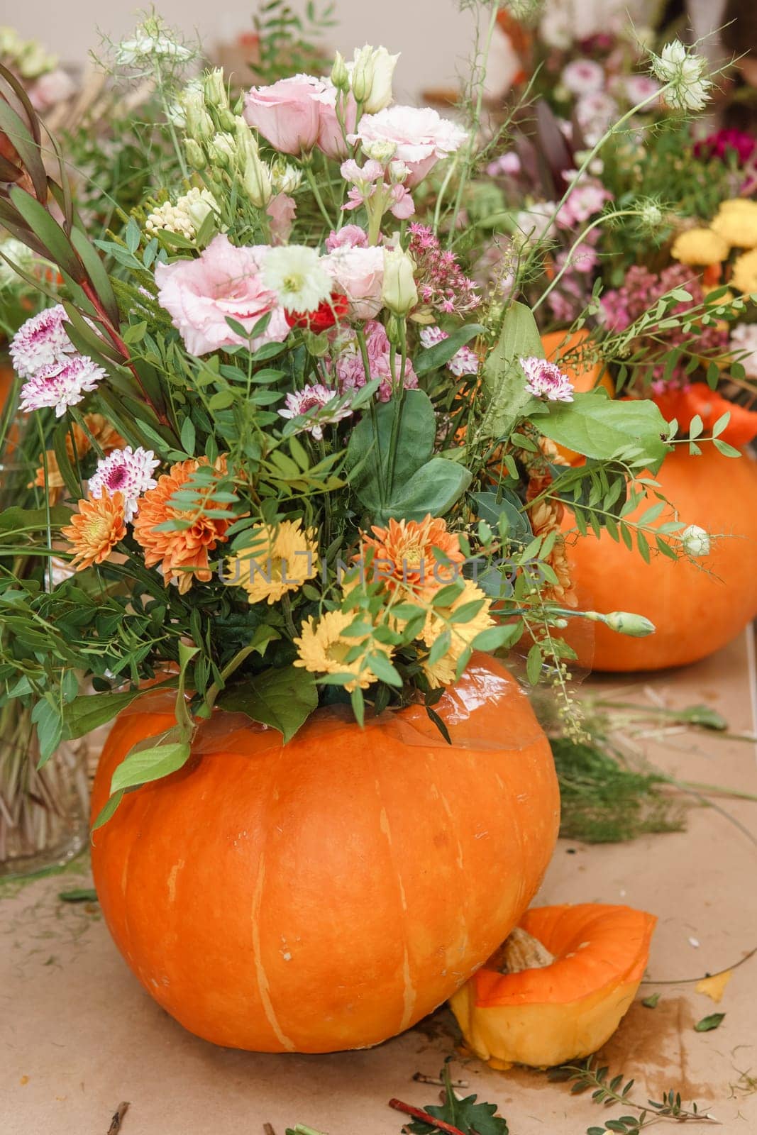 Flower arrangement in a pumpkin, autumn interior decor. Creating handmade autumn decor
